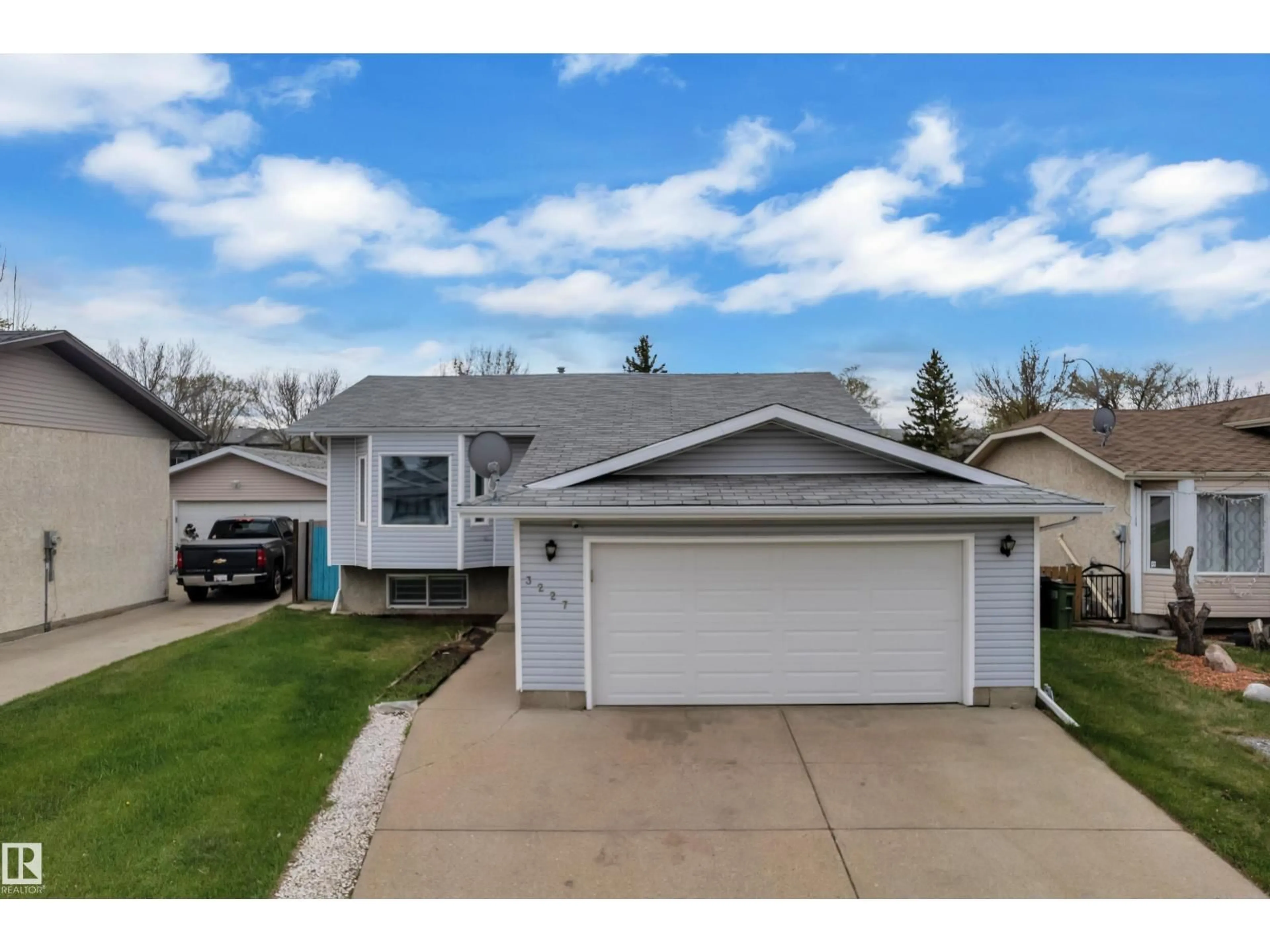 Home with vinyl exterior material, street for NW - 3227 145 AV, Edmonton Alberta T5Y2E9