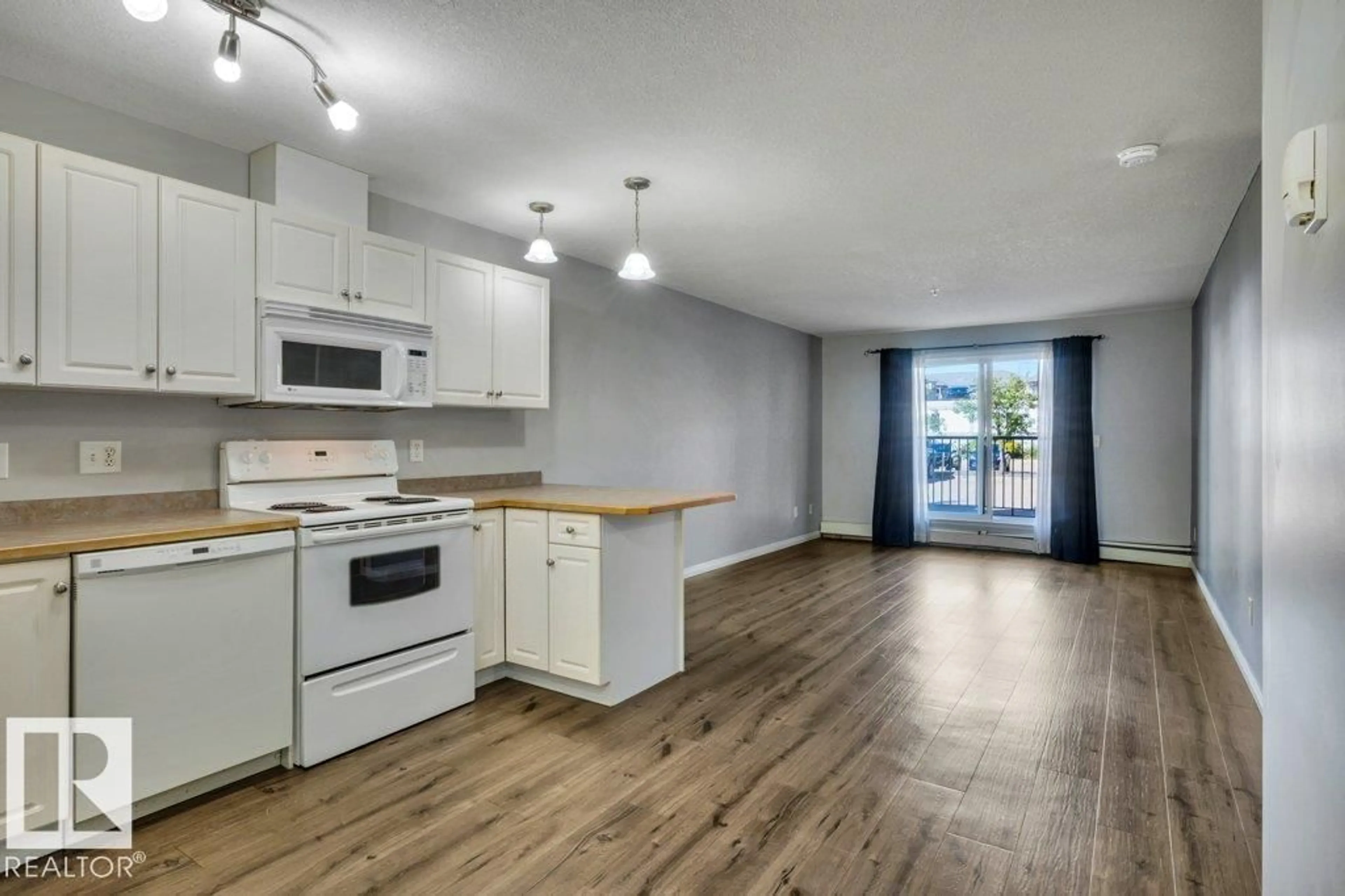 Open concept kitchen, wood/laminate floor for #122 - 12550 140 AV, Edmonton Alberta T5X6J4