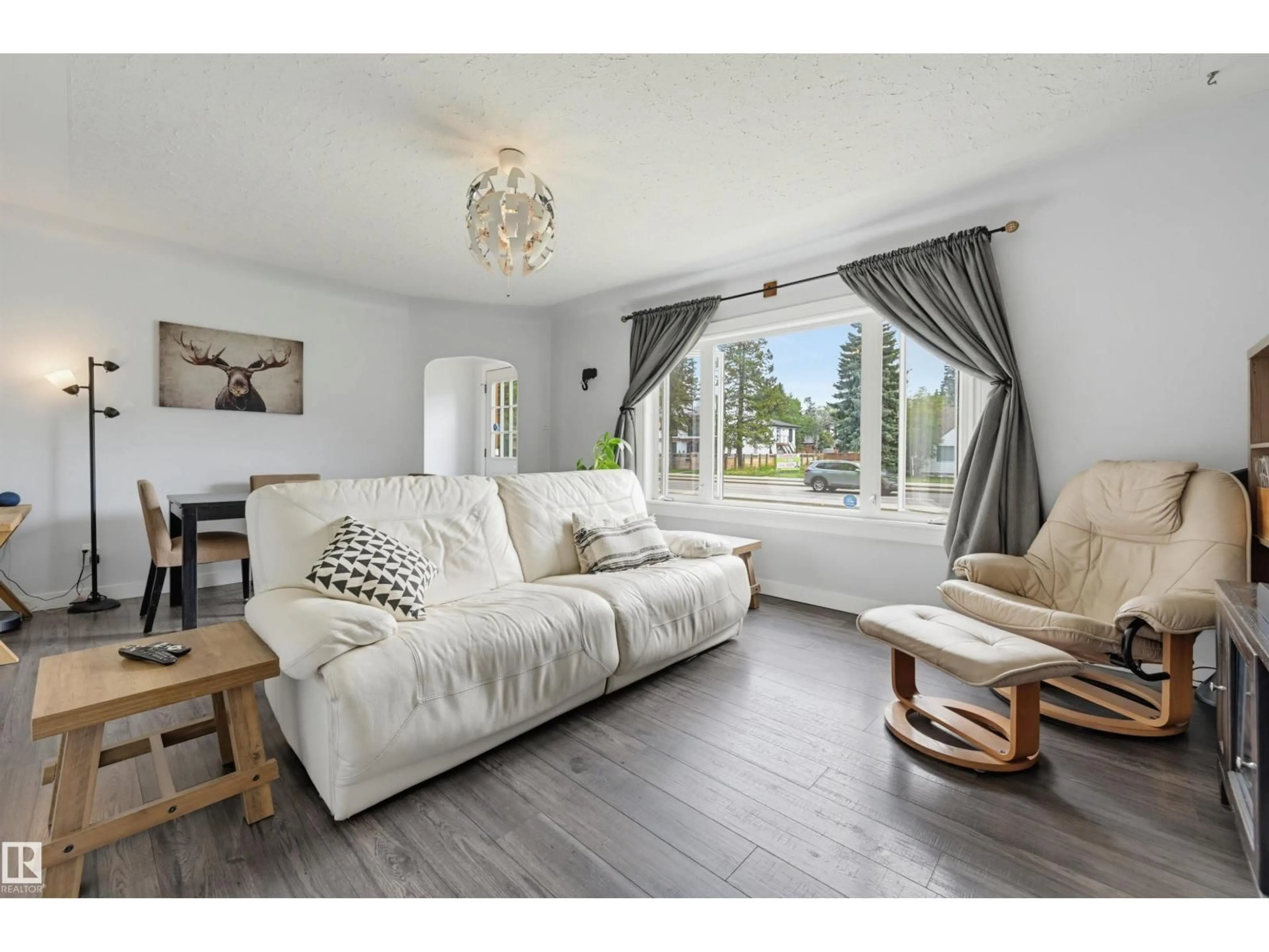 Living room with furniture, wood/laminate floor for 10670 61 AV, Edmonton Alberta T6H1L7