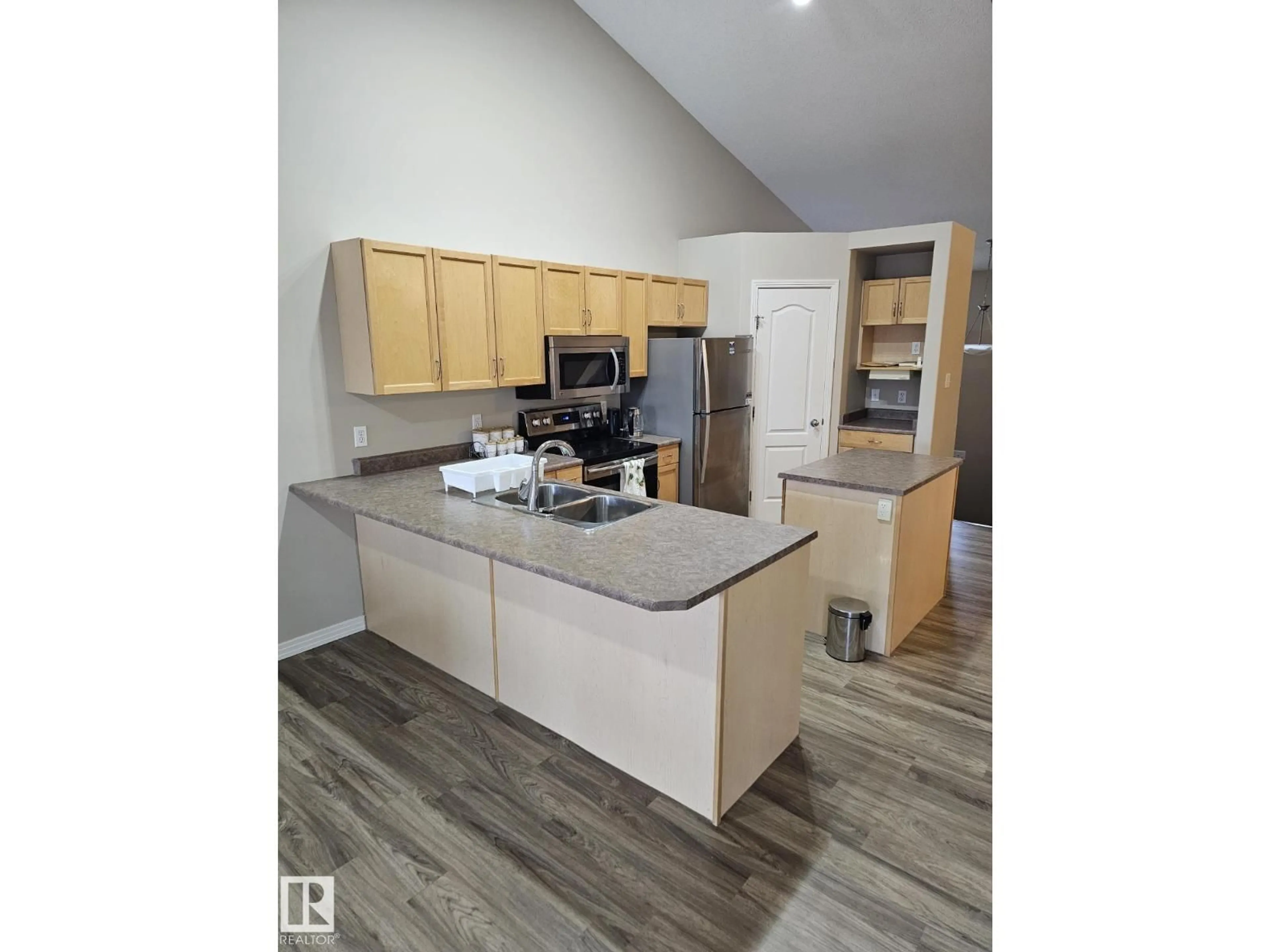 Open concept kitchen, wood/laminate floor for NW - 4315 151 AV, Edmonton Alberta T5Y3A9