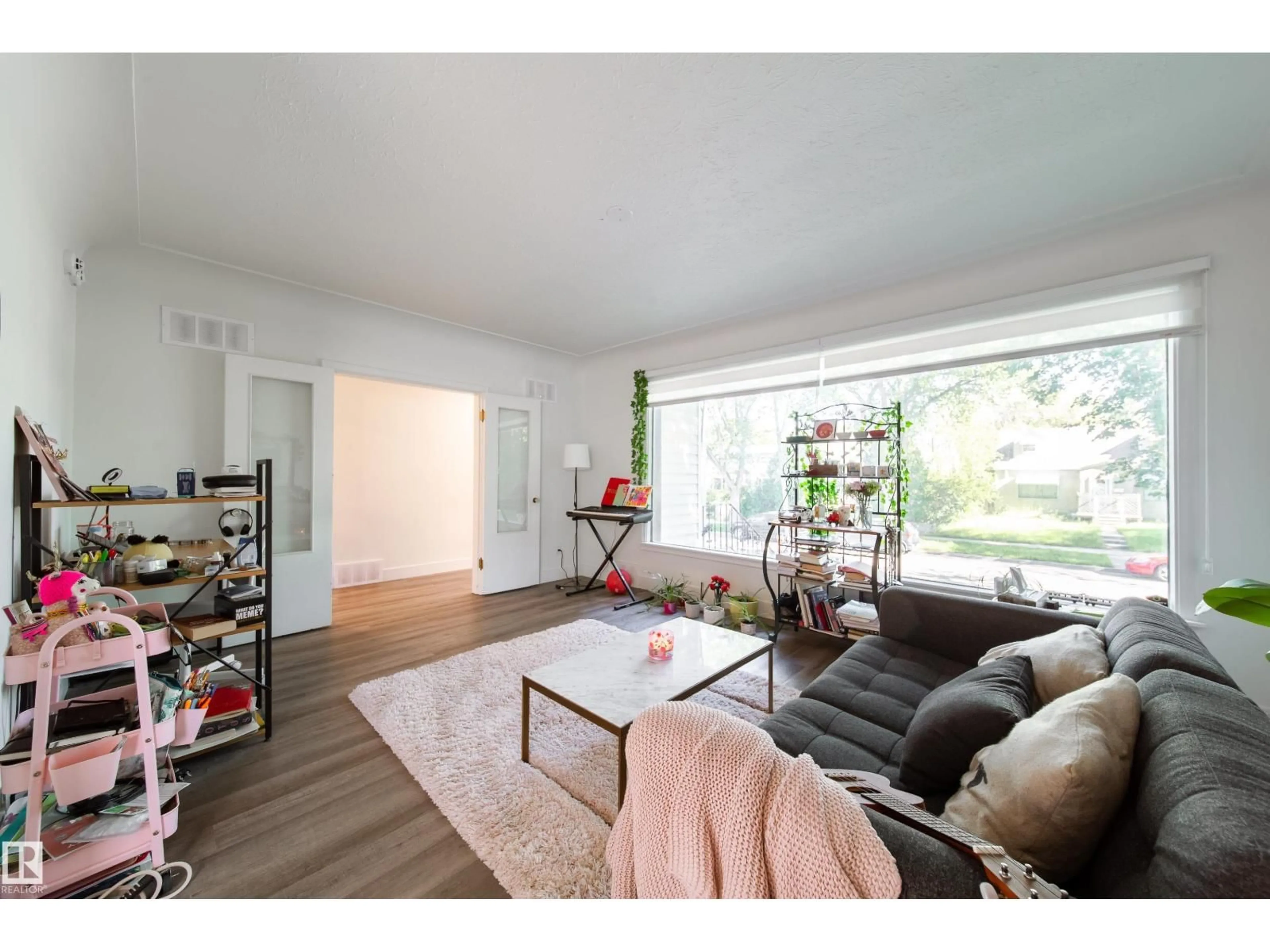 Living room with furniture, wood/laminate floor for 10671 63 AV, Edmonton Alberta T6H1P7