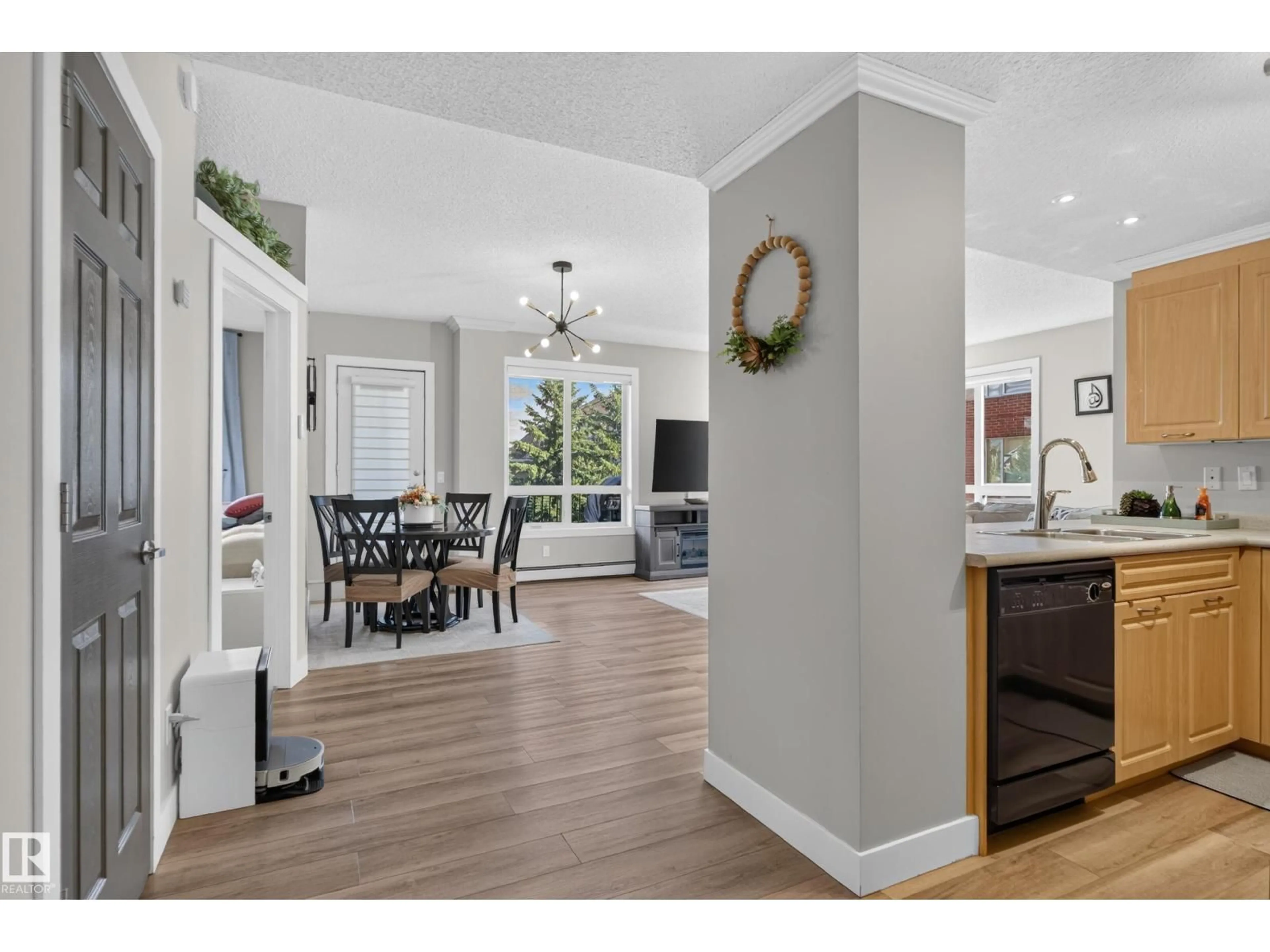 Open concept kitchen, wood/laminate floor for #227 - 6315 135 AV, Edmonton Alberta T5A5J7