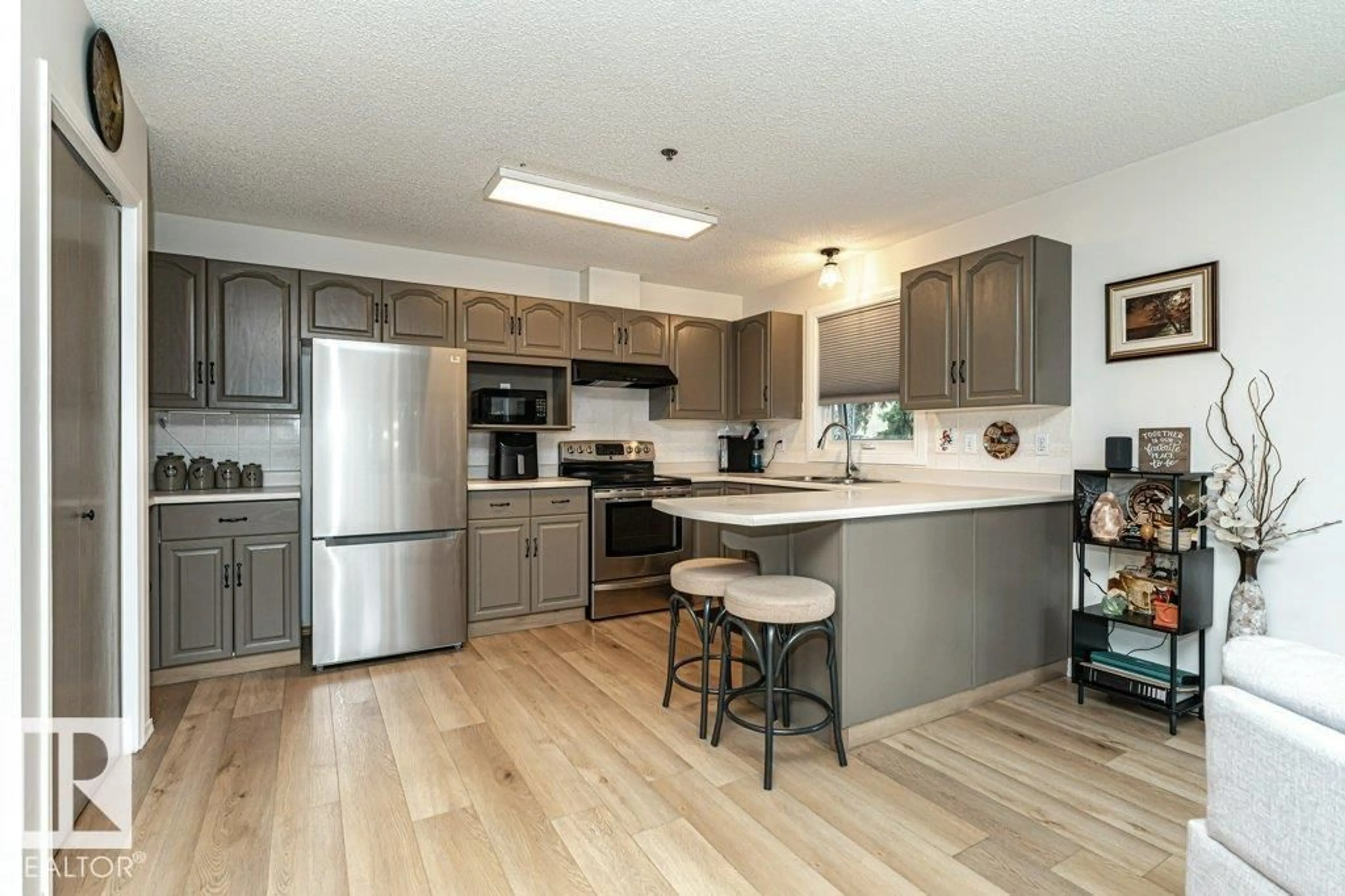 Open concept kitchen, wood/laminate floor for #211 - 10610 76 ST, Edmonton Alberta T6A3Y9