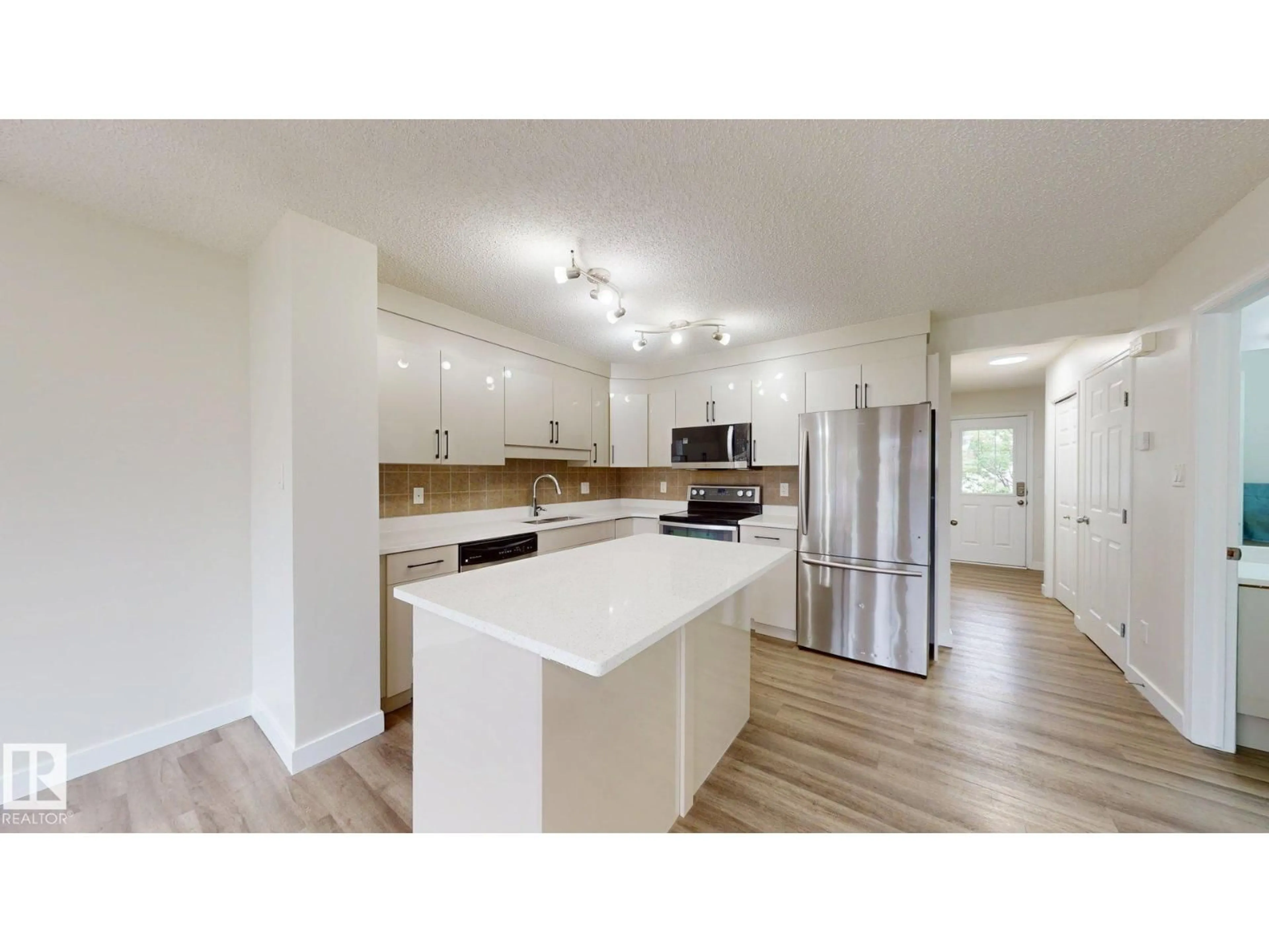 Open concept kitchen, wood/laminate floor for NW - 1150 37B AV, Edmonton Alberta T6T0E6