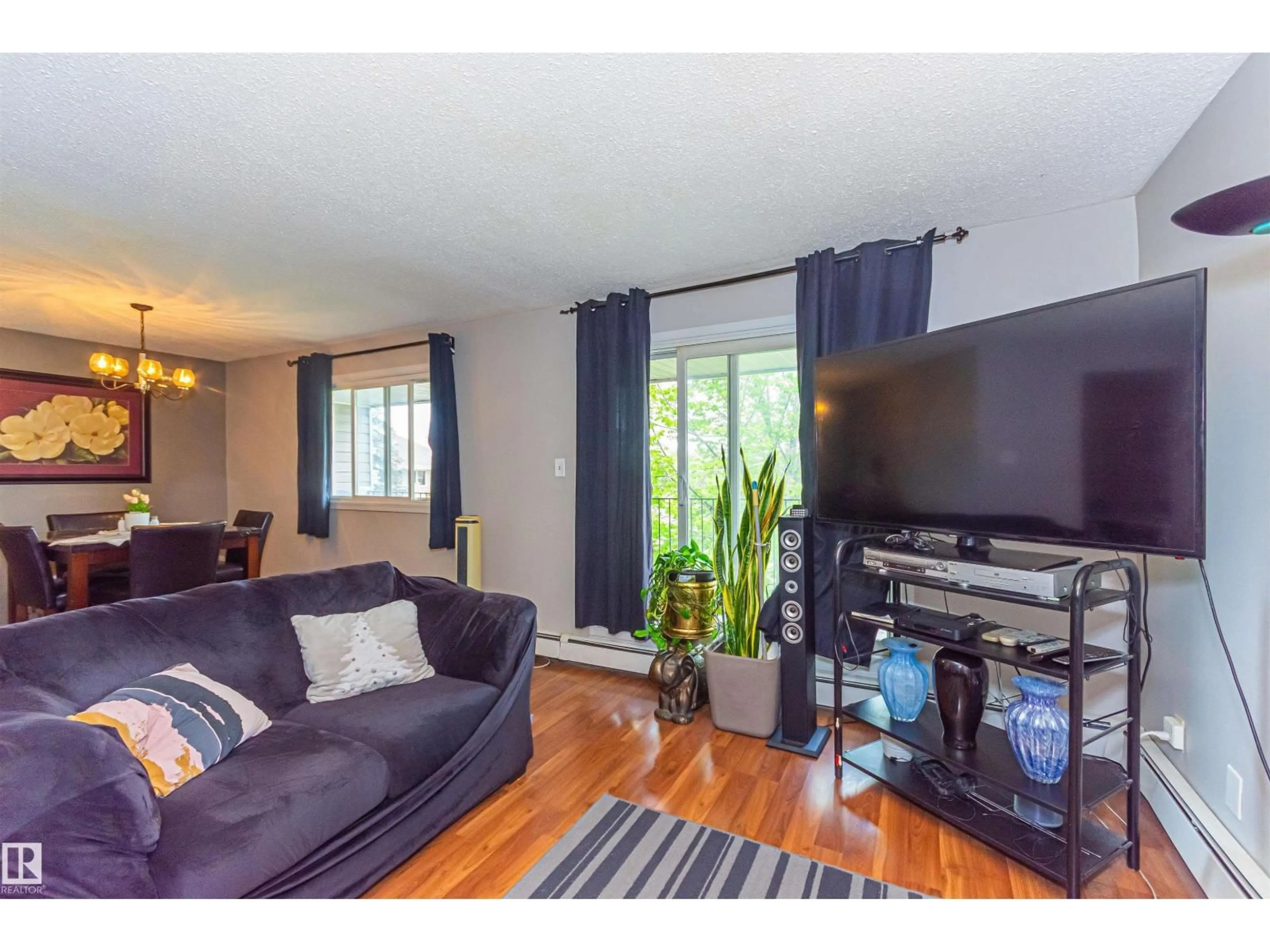 Living room with furniture, wood/laminate floor for 6 - 3819 76 ST, Edmonton Alberta T6K2P9