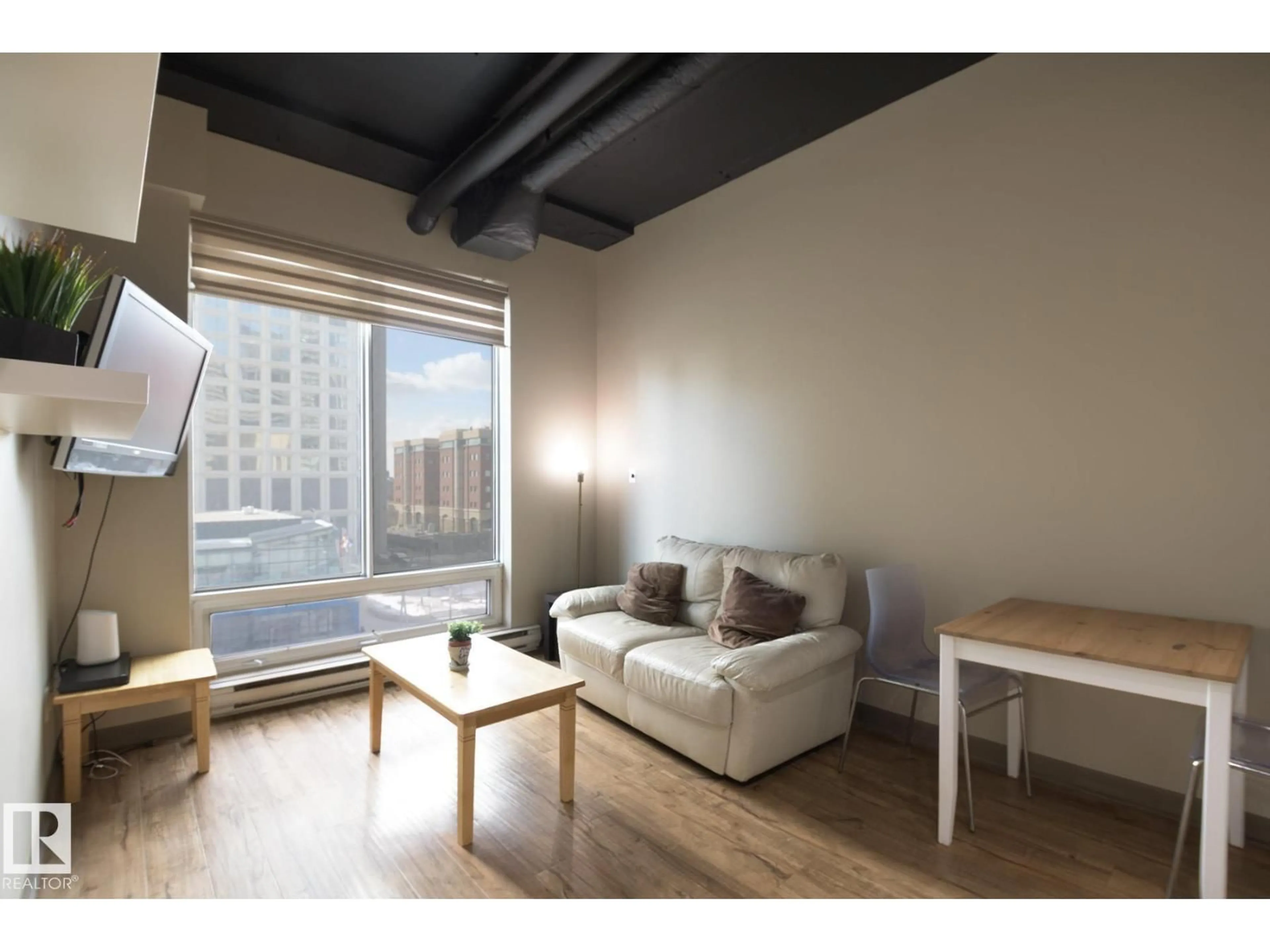 Living room with furniture, wood/laminate floor for 10024 - 412 JASPER AV, Edmonton Alberta T5J1R9