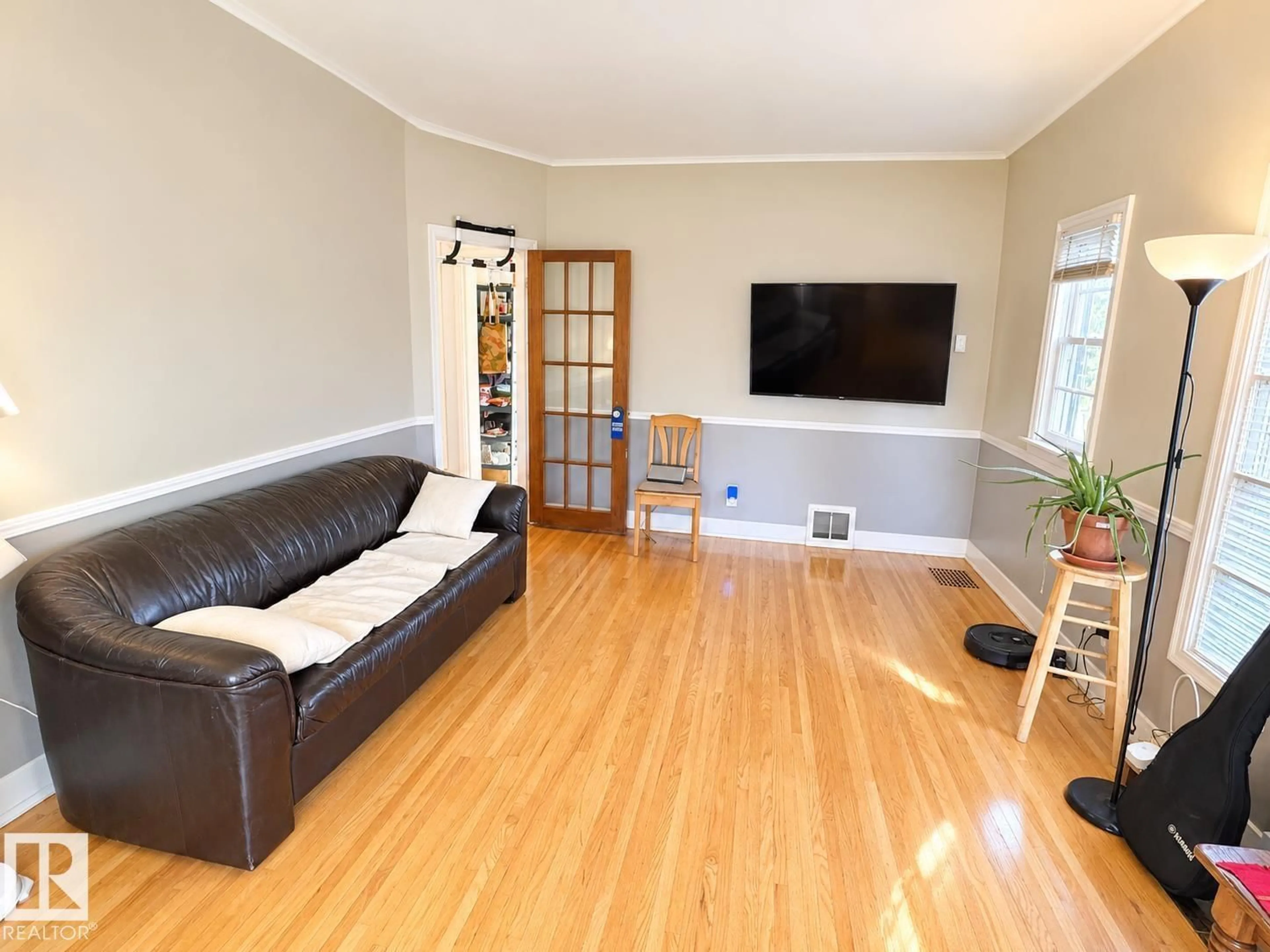 Living room with furniture, wood/laminate floor for 8907 83 AV NW, Edmonton Alberta T6C1B4