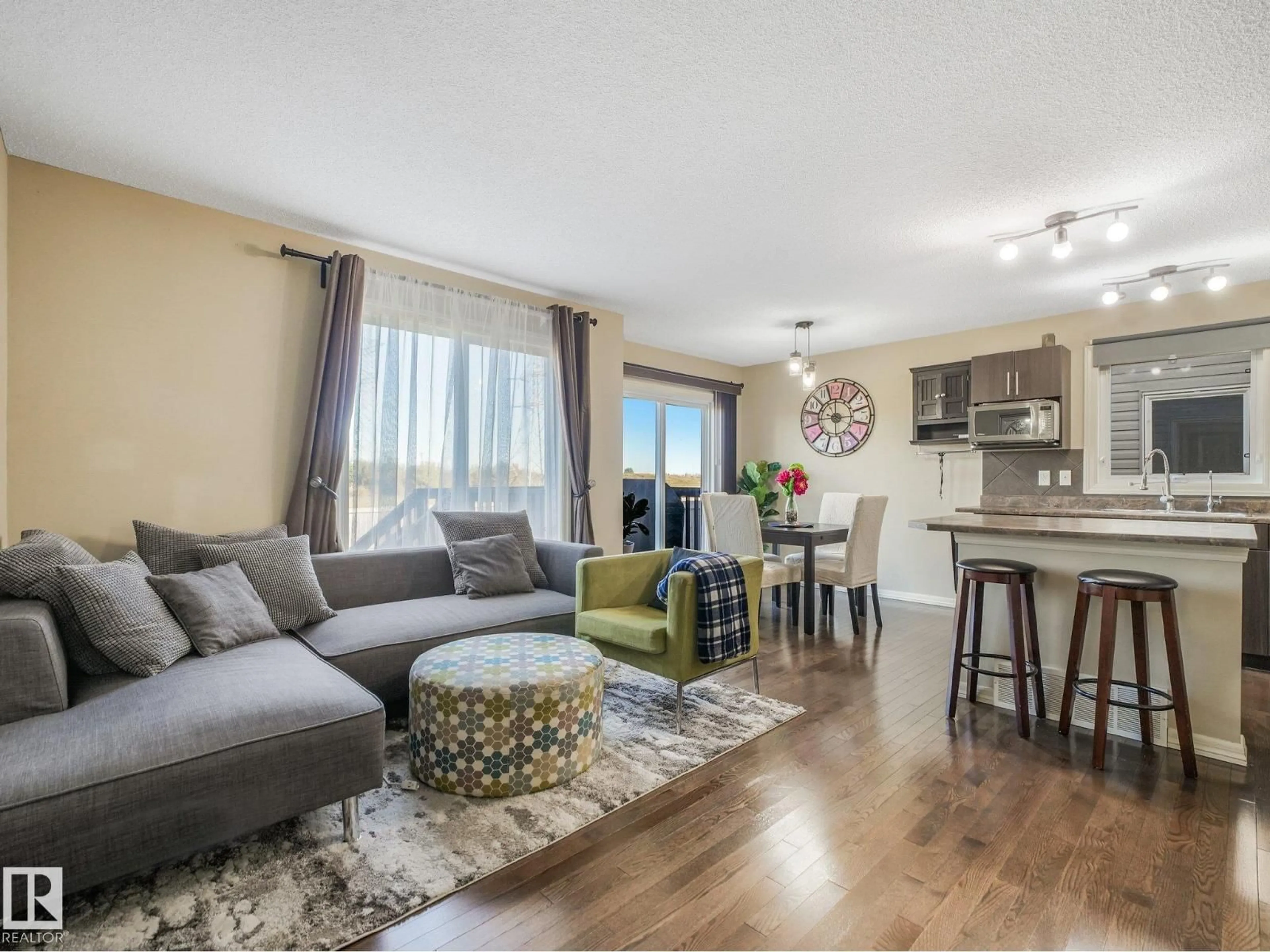 Living room with furniture, wood/laminate floor for SW - 5220 1A AV, Edmonton Alberta T6X0X1