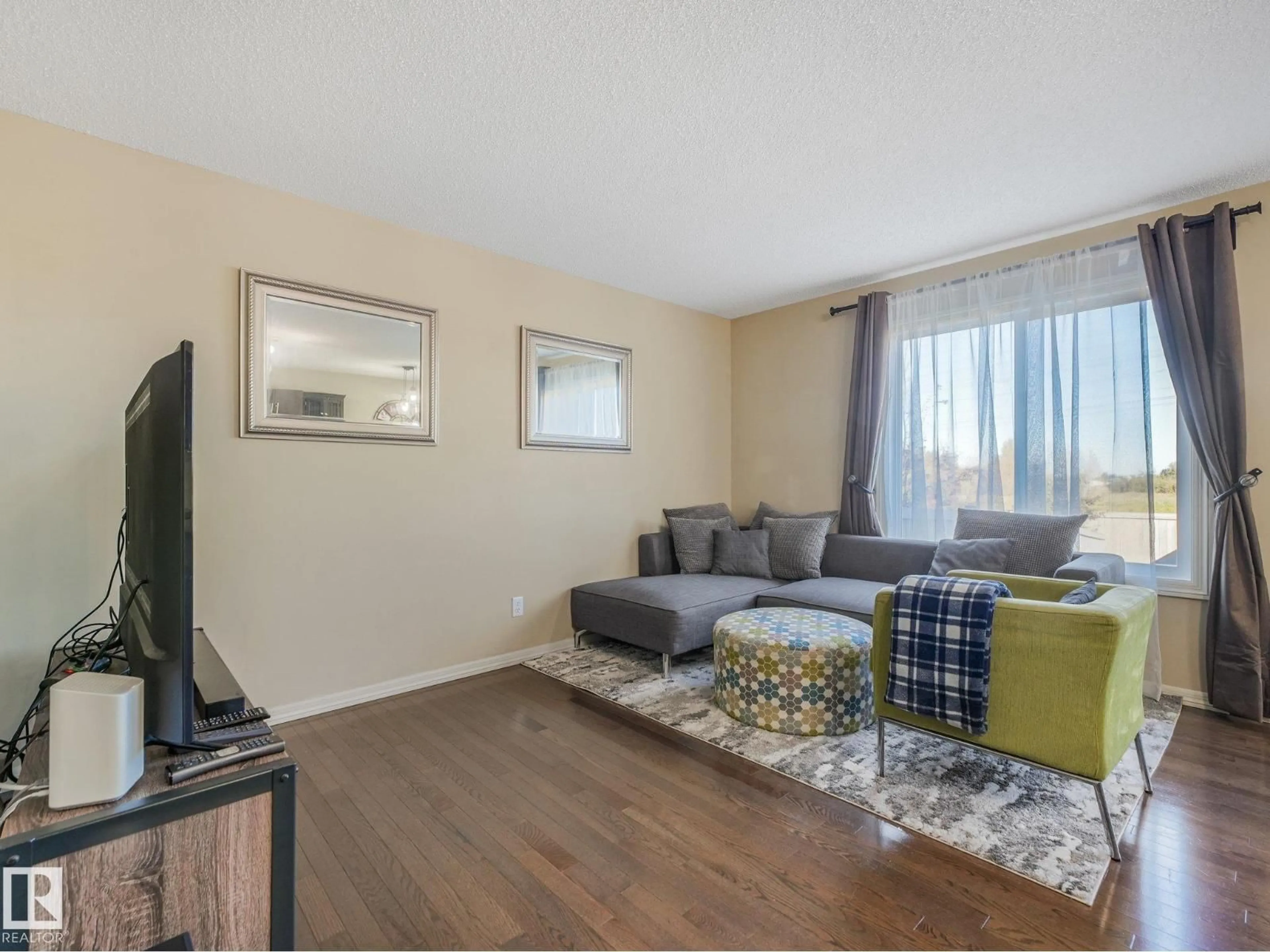 Living room with furniture, wood/laminate floor for SW - 5220 1A AV, Edmonton Alberta T6X0X1