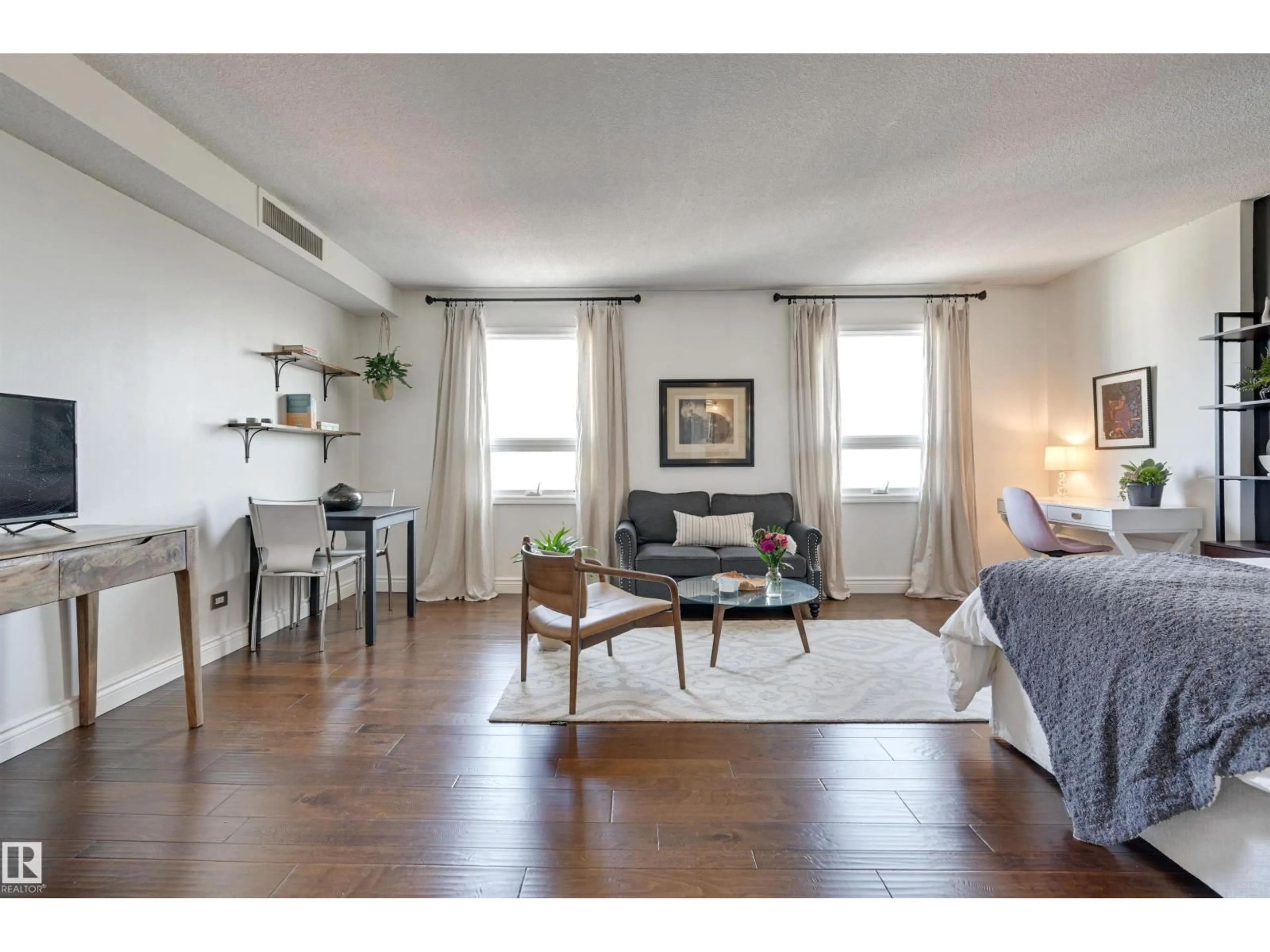 Living room with furniture, wood/laminate floor for 10140 NW - 1505 120 ST, Edmonton Alberta T5K1Z8