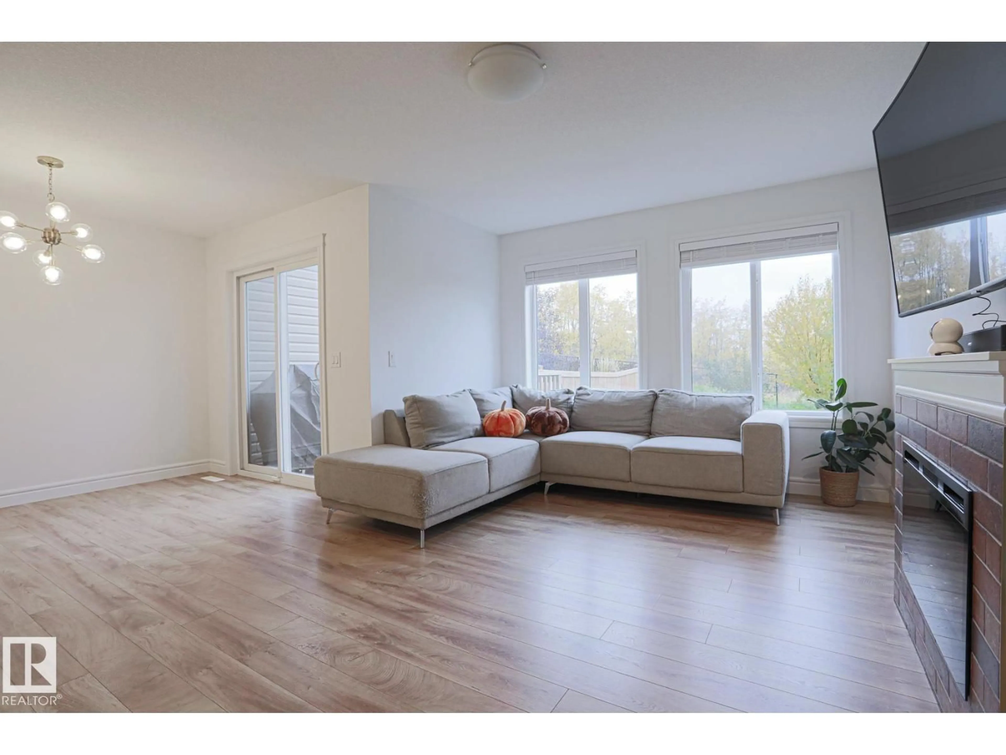 Living room with furniture, wood/laminate floor for 3833 ROBINS CR, Edmonton Alberta T5S0M7