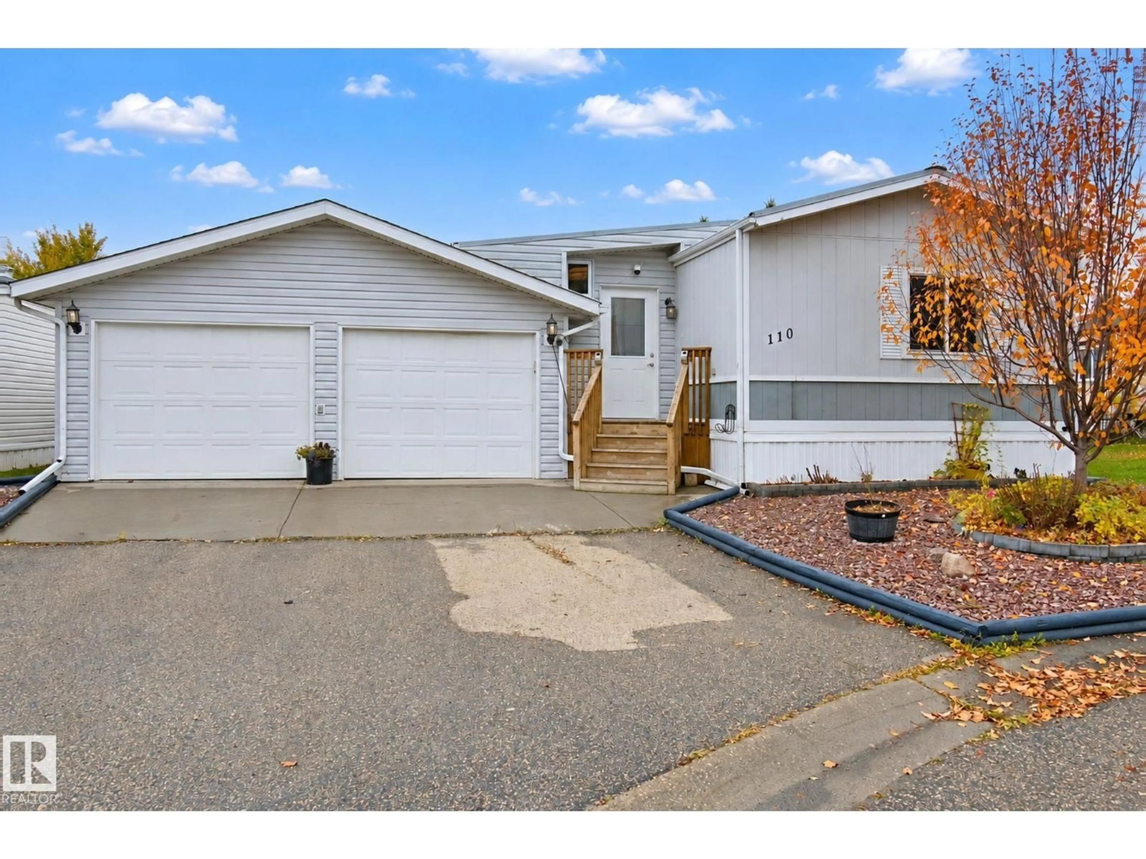 Home with vinyl exterior material, street for 110 - 3400 48 ST, Stony Plain Alberta T7Z1W2