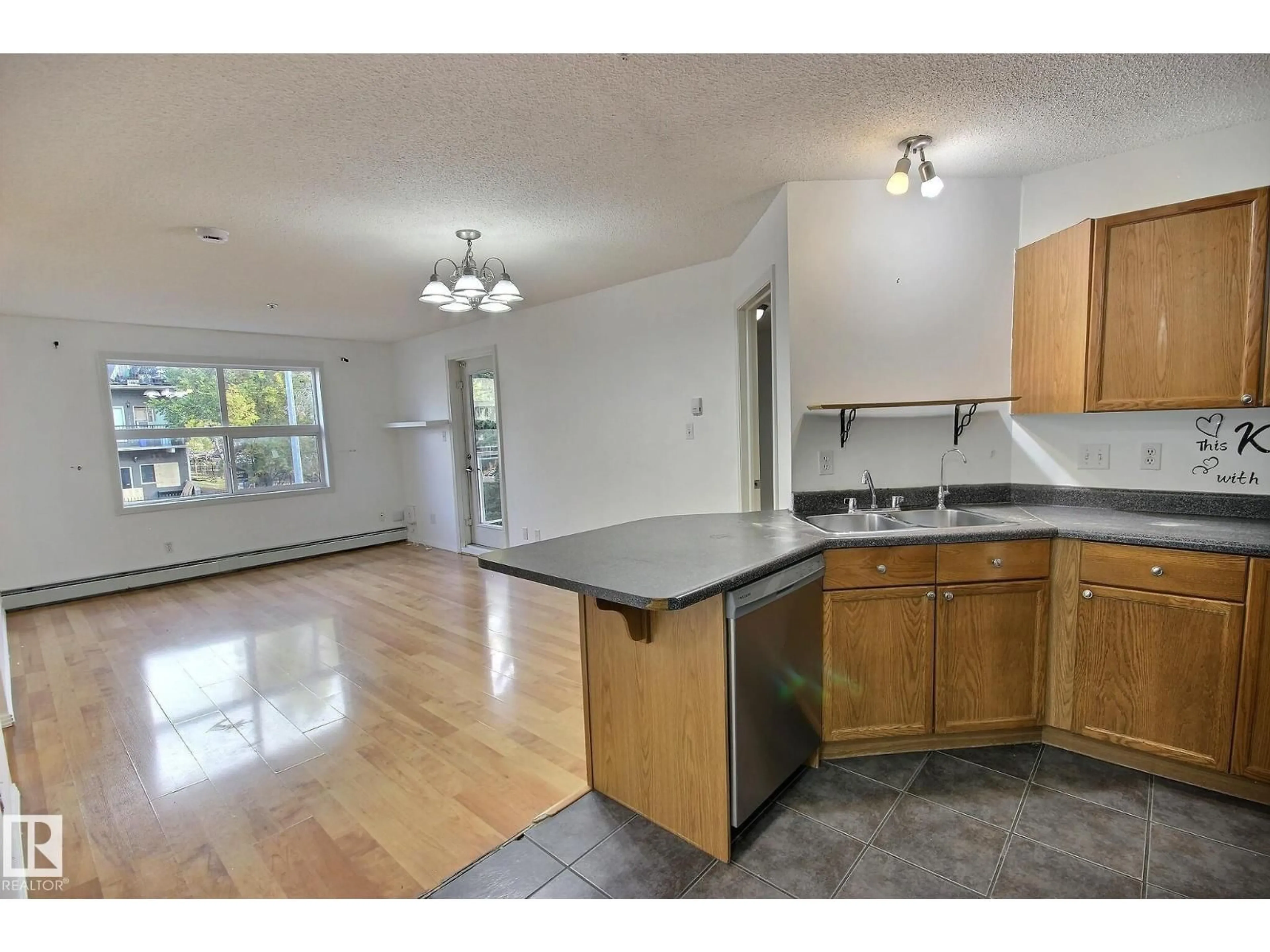 Open concept kitchen, wood/laminate floor for 218 12838 65 ST NW, Edmonton Alberta T5A5H3