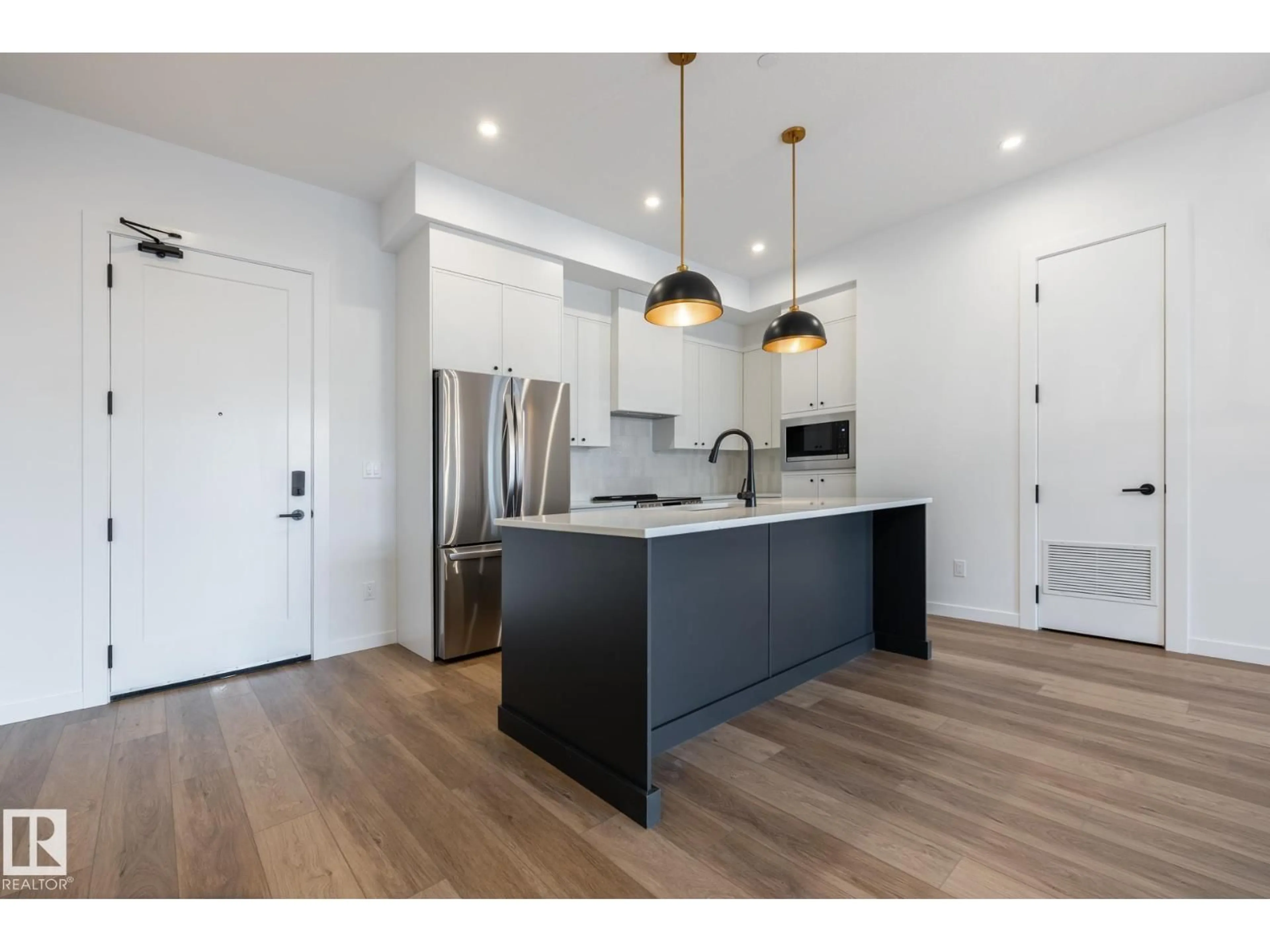 Open concept kitchen, wood/laminate floor for #102 - 7459 MAY COMMON, Edmonton Alberta T6R0X6