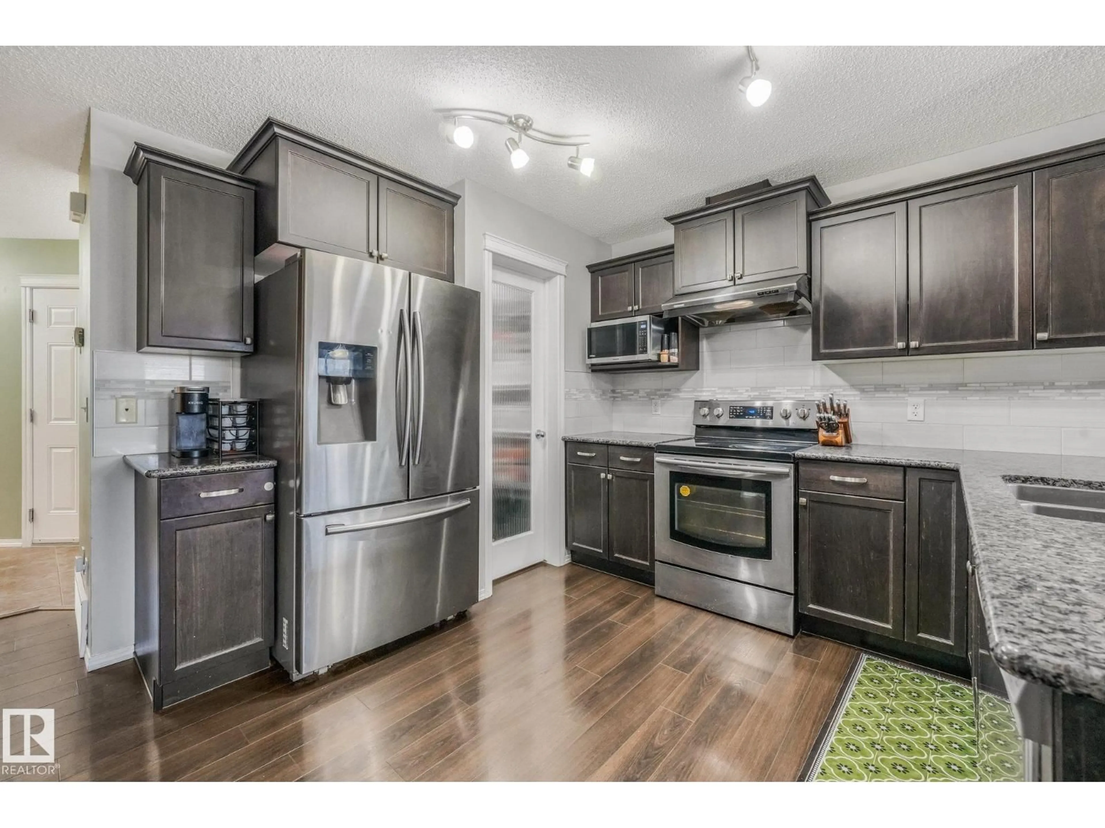Open concept kitchen, wood/laminate floor for 1947 118 ST, Edmonton Alberta T6W2E4