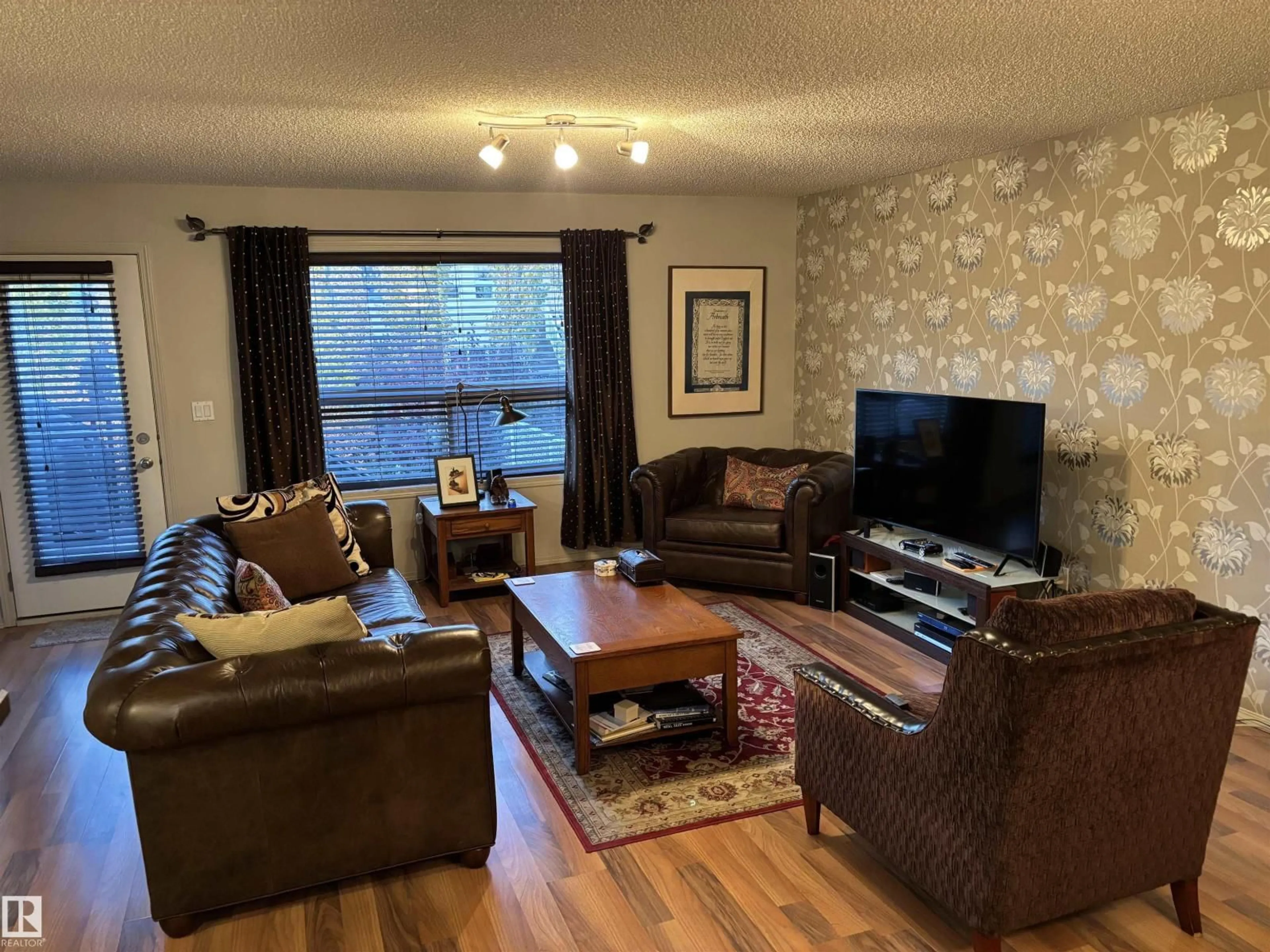 Living room with furniture, wood/laminate floor for 711 KANANASKIS DR, Devon Alberta T9G2G7