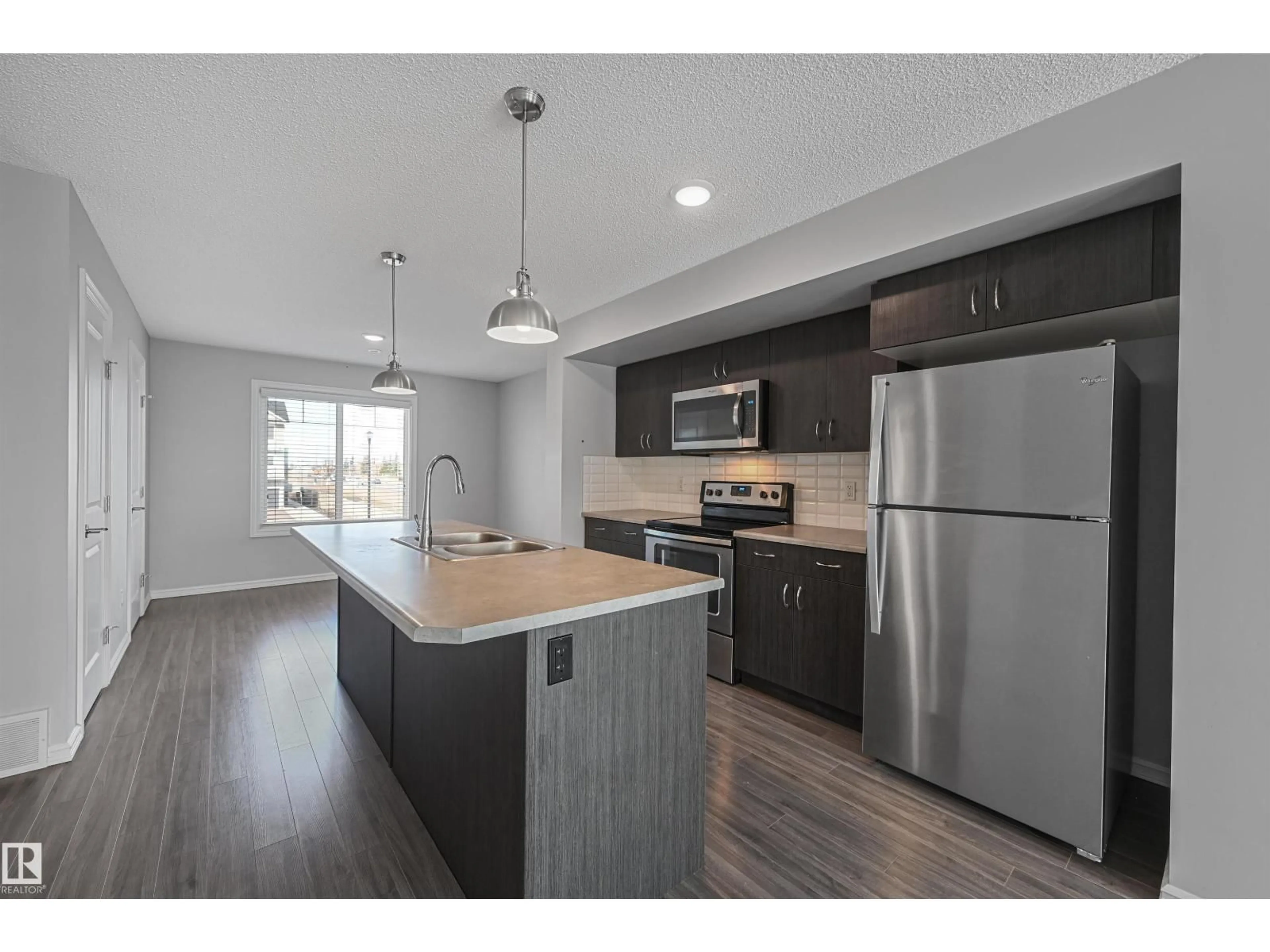 Open concept kitchen, wood/laminate floor for #34 - 2215 24 ST, Edmonton Alberta T6T1A6