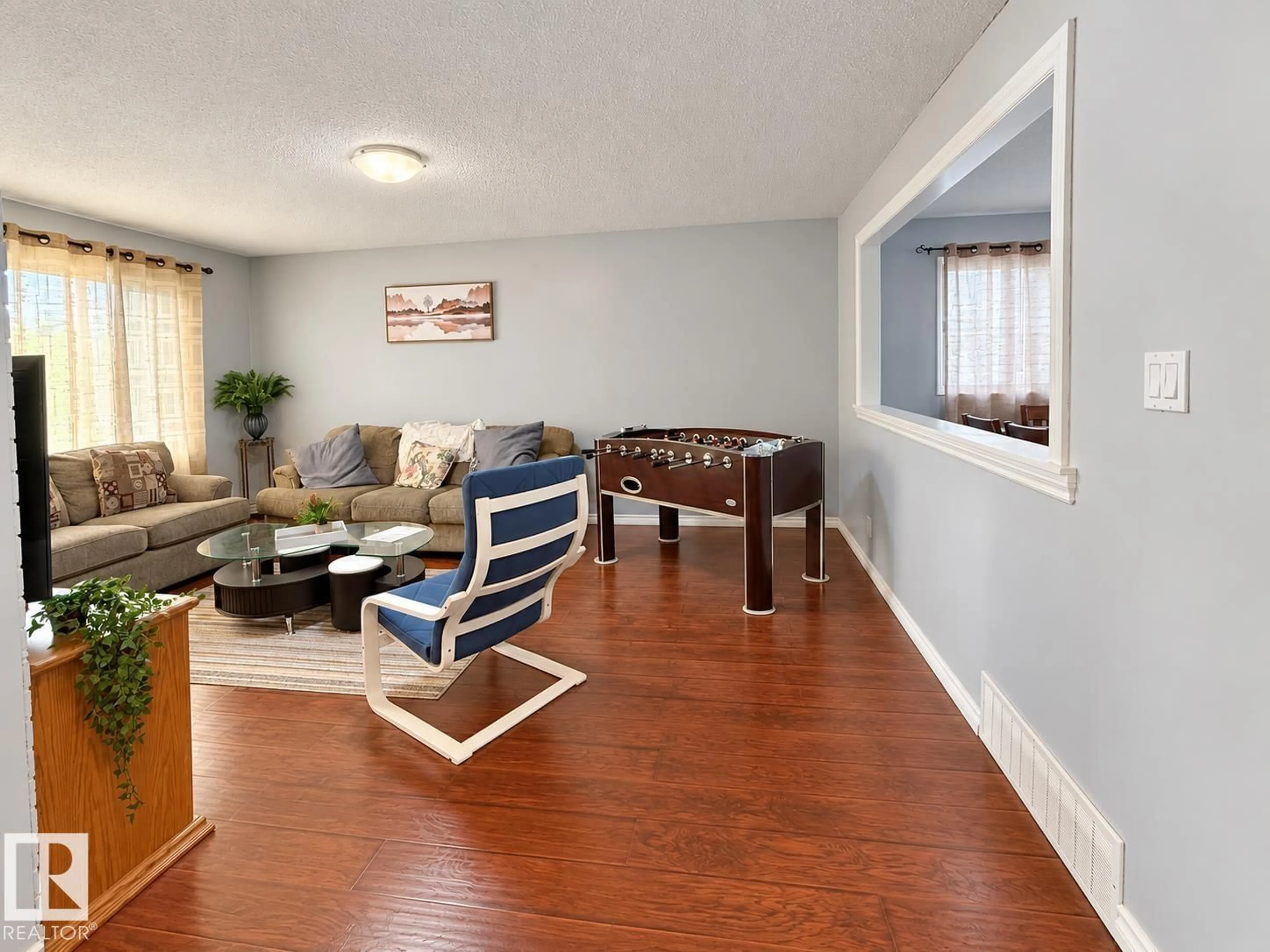 Living room with furniture, wood/laminate floor for 8412 35 AV, Edmonton Alberta T6K0C6