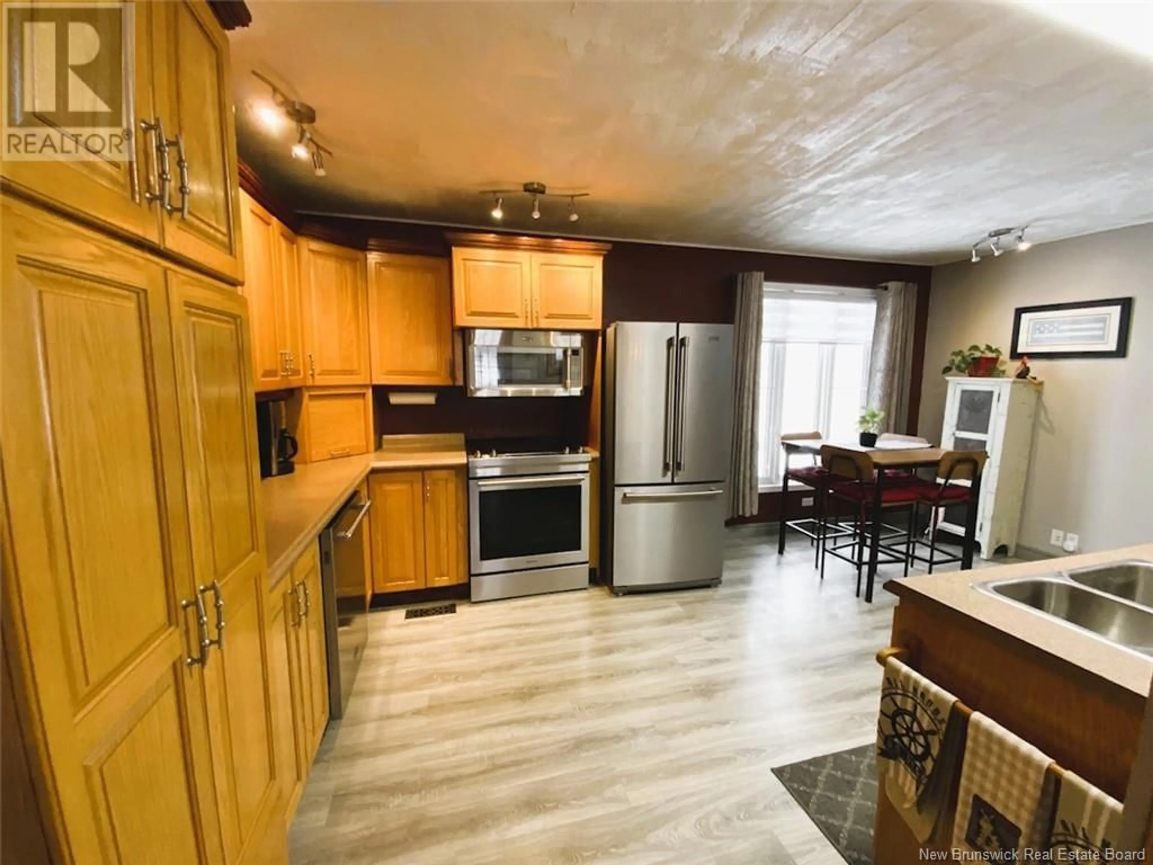 Open concept kitchen, wood/laminate floor for 871 Canada Road, Edmundston New Brunswick E3V3X1