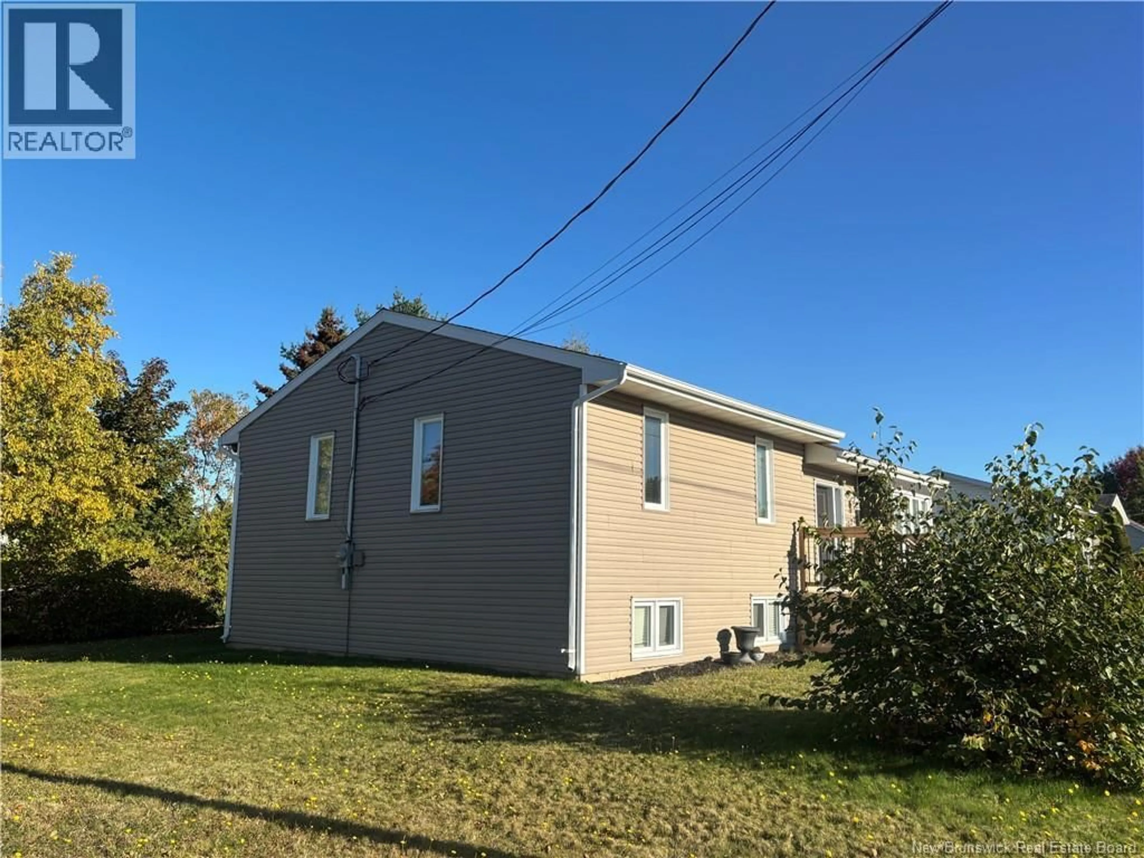Home with vinyl exterior material, street for 1027 RUE HACHE, Beresford New Brunswick E8K1H9