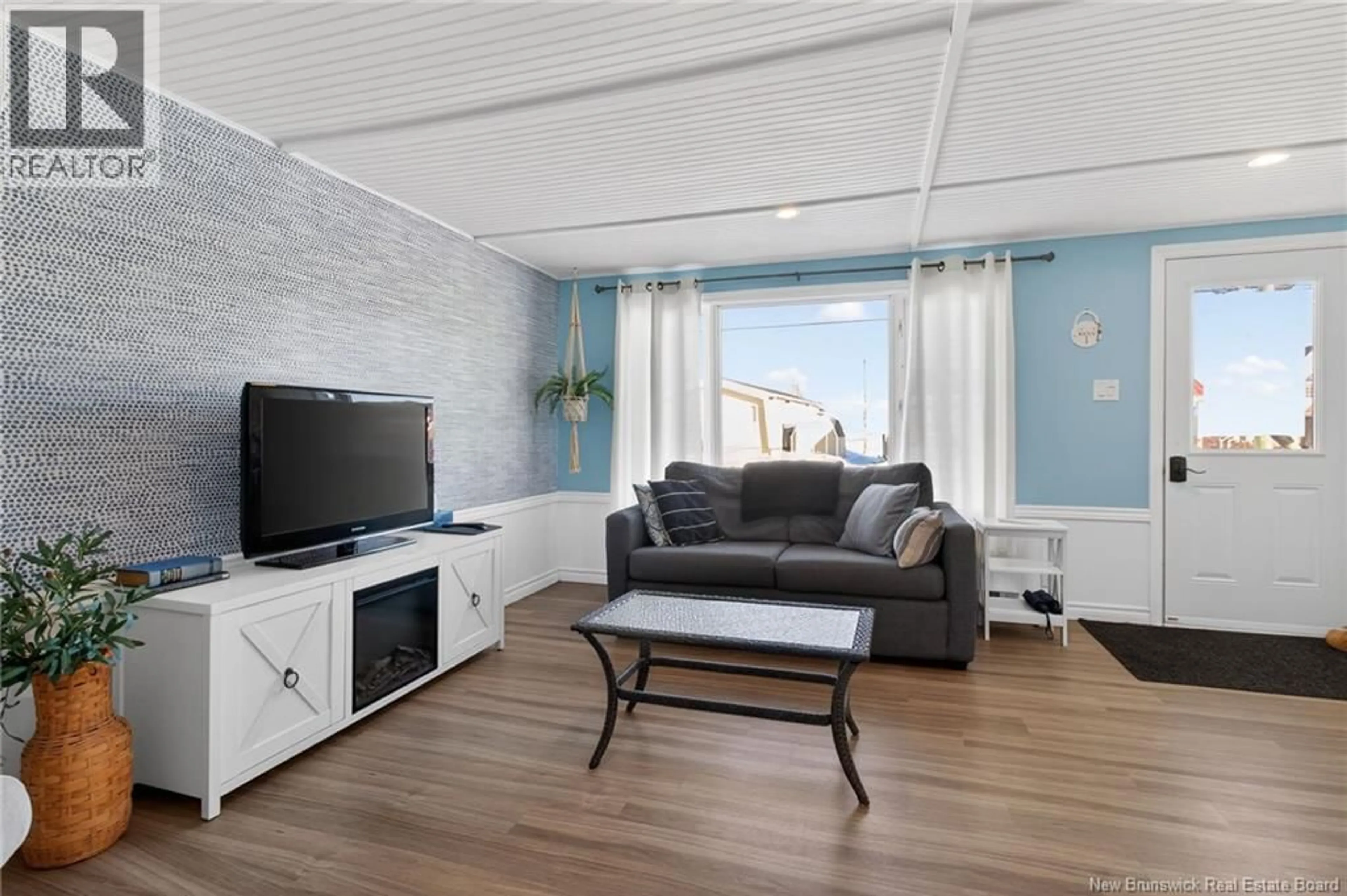 Living room with furniture, wood/laminate floor for 57 BAYBREEZE LANE, Grand-Barachois New Brunswick E4P6W9