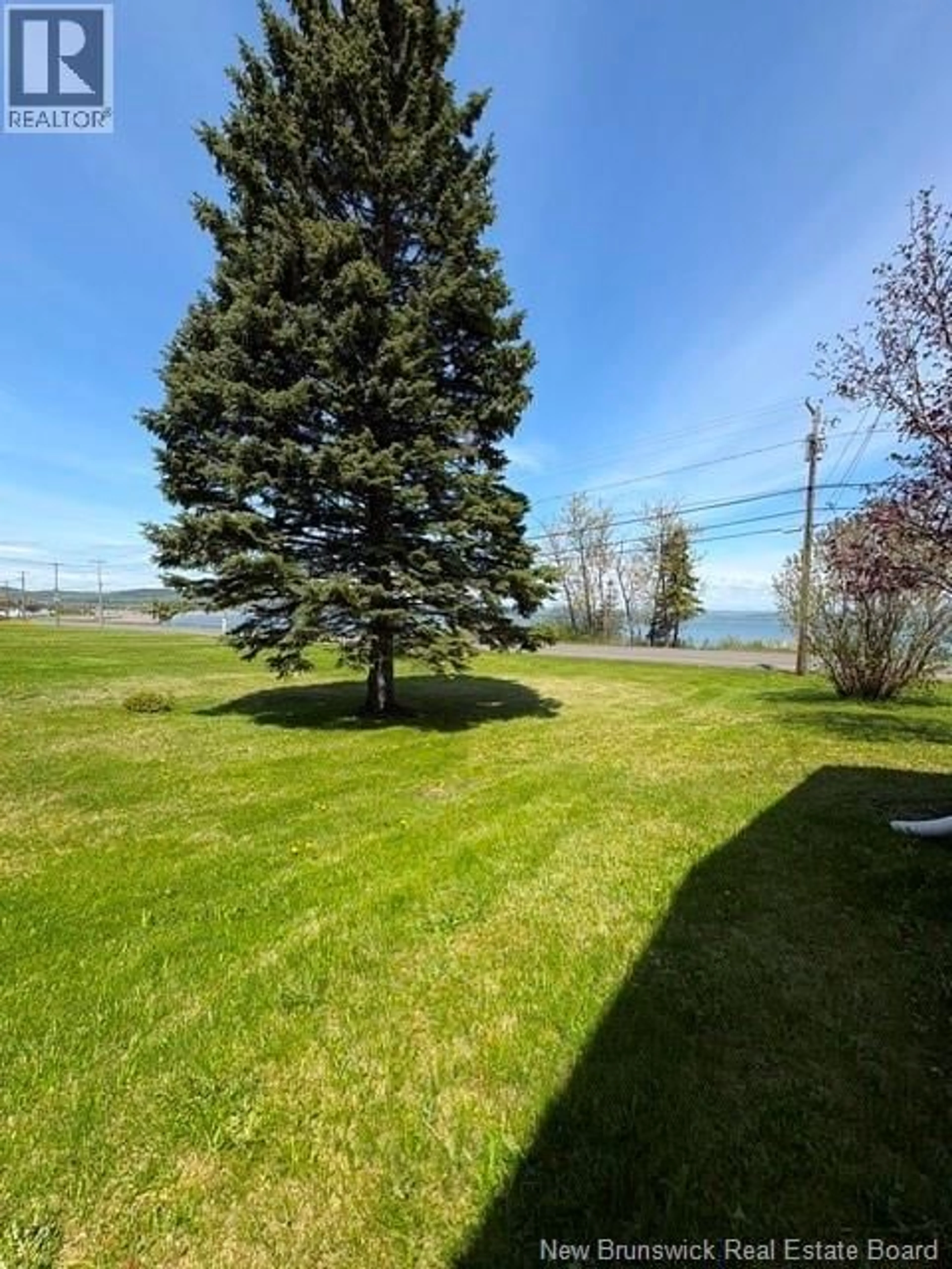 A pic from outside/outdoor area/front of a property/back of a property/a pic from drone, water/lake/river/ocean view for 94 CHALEUR STREET, Charlo New Brunswick E8E2E7