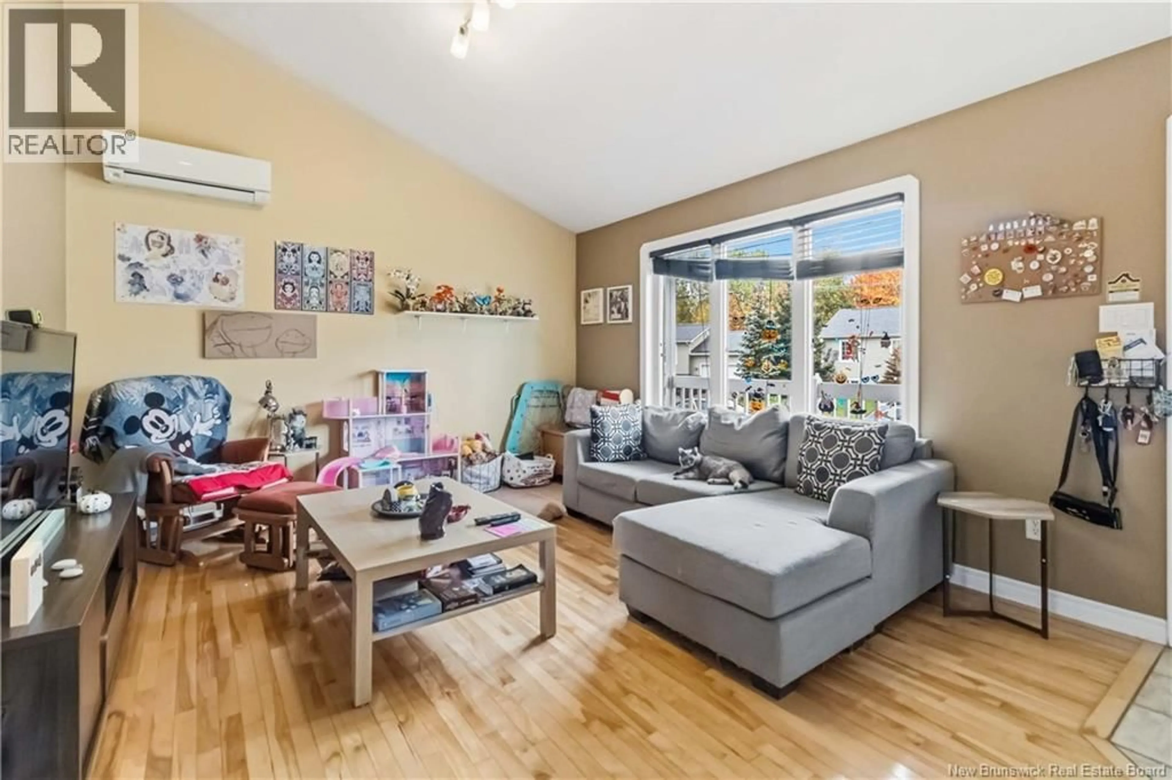 Living room with furniture, wood/laminate floor for 107 RUE CYRIL, Dieppe New Brunswick E1A8R7