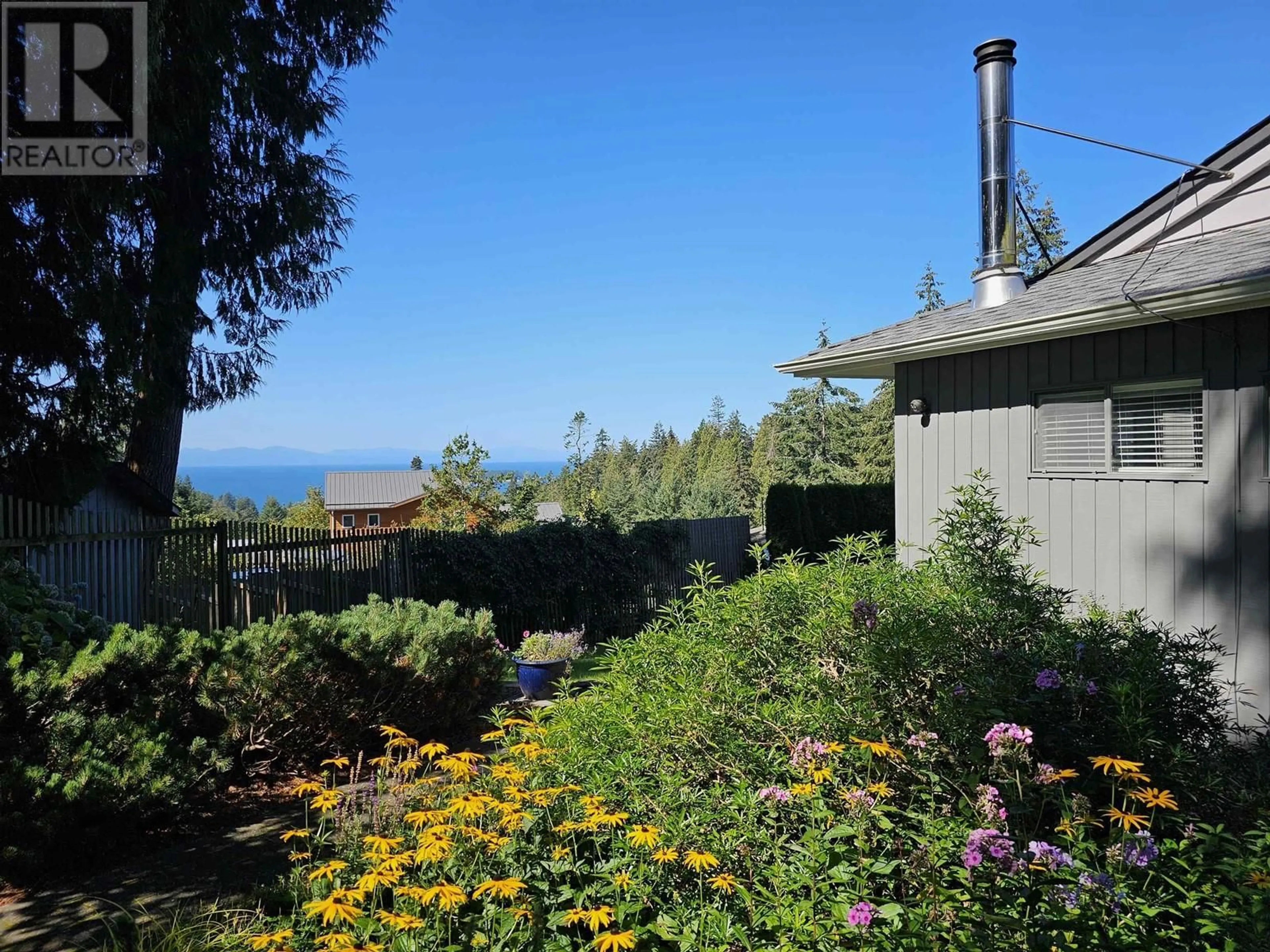 A pic from exterior of the house or condo, the fenced backyard for 1526 WHITESAILS DRIVE, Bowen Island British Columbia V0N1G2