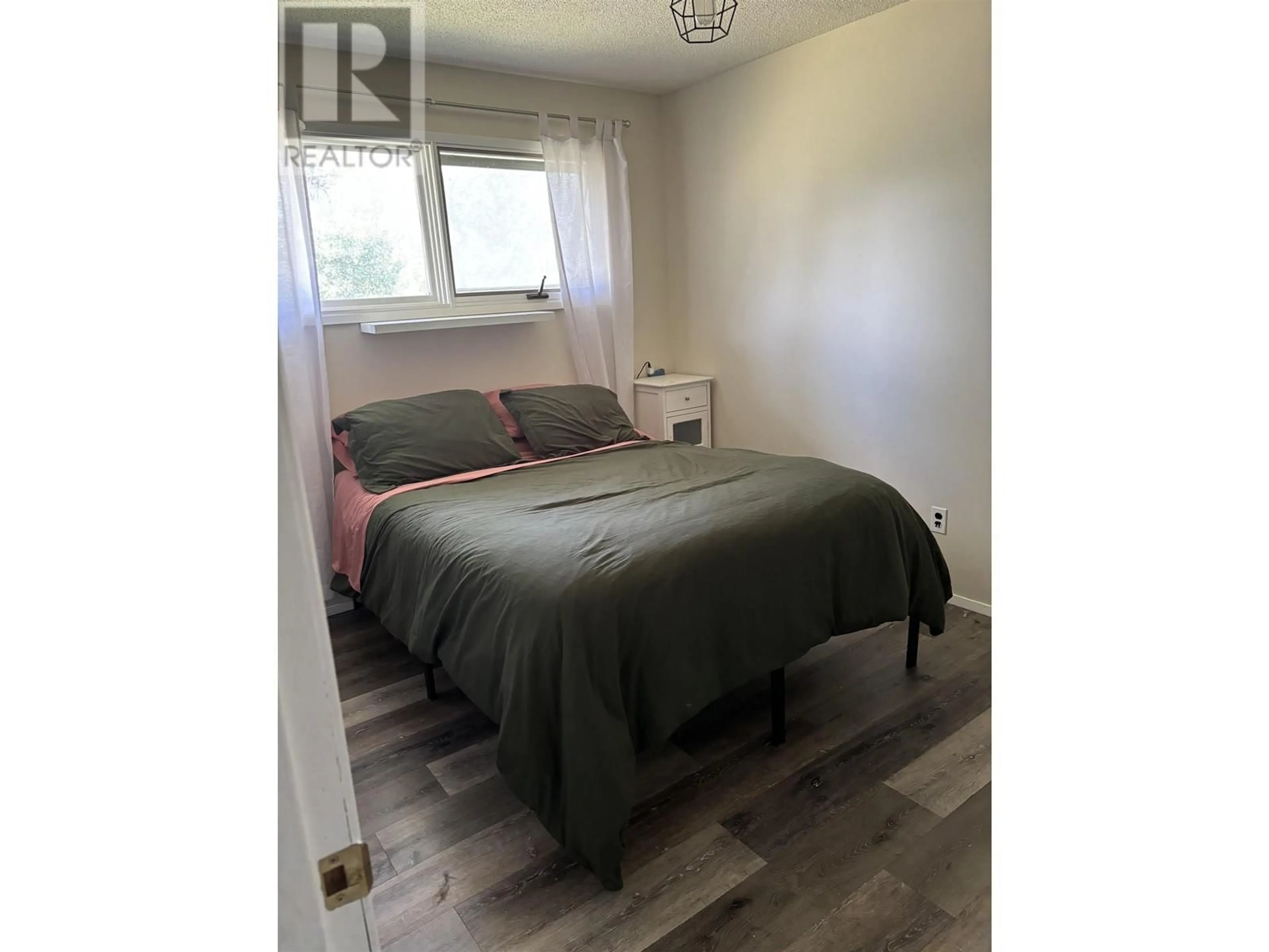 Bedroom with bed, wood/laminate floor for 6365 MARIGOLD AVENUE, Fort St. John British Columbia V1J8B6