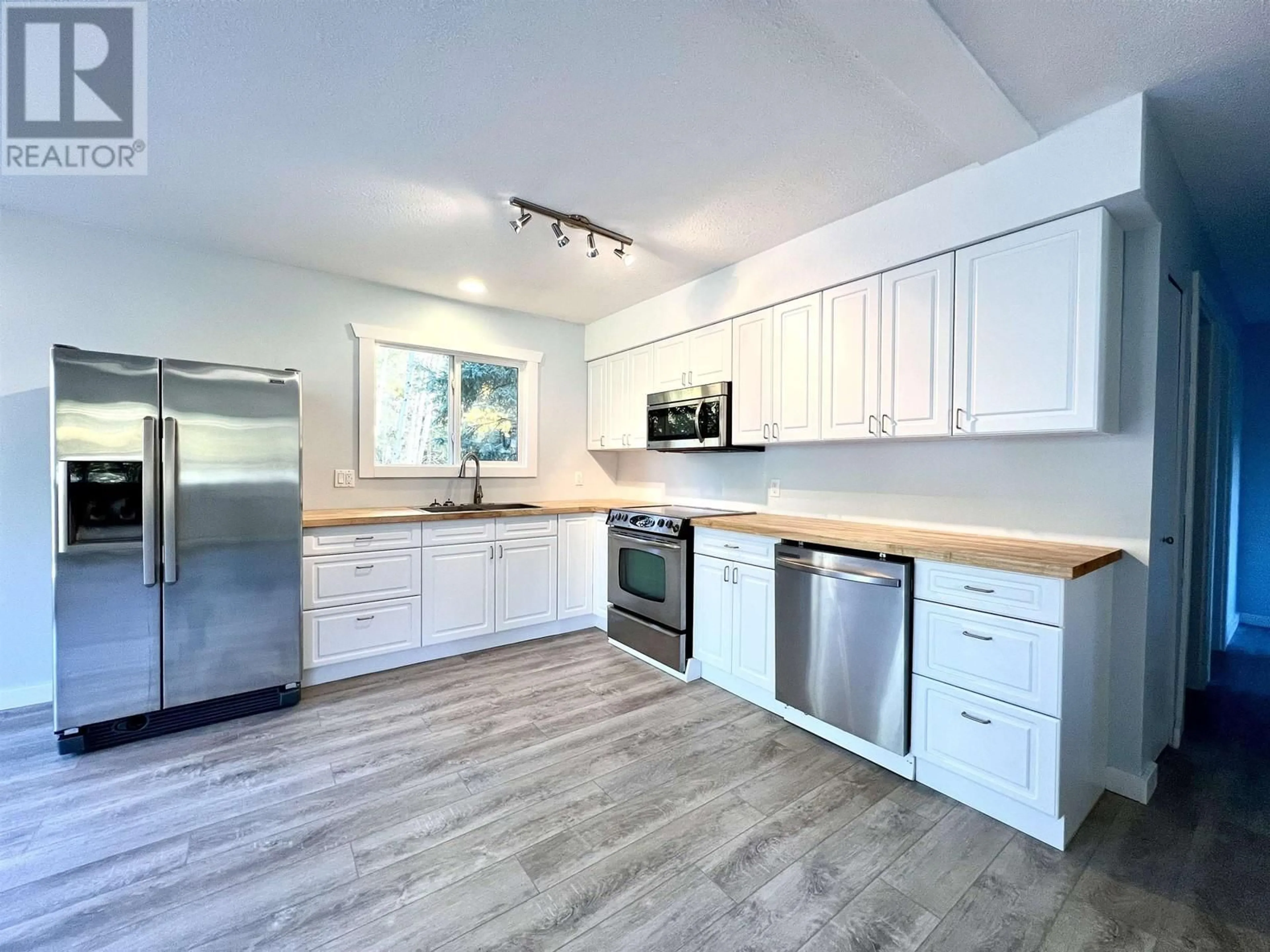 Open concept kitchen, wood/laminate floor for 6053 HORSE LAKE ROAD, 100 Mile House British Columbia V0K2E3