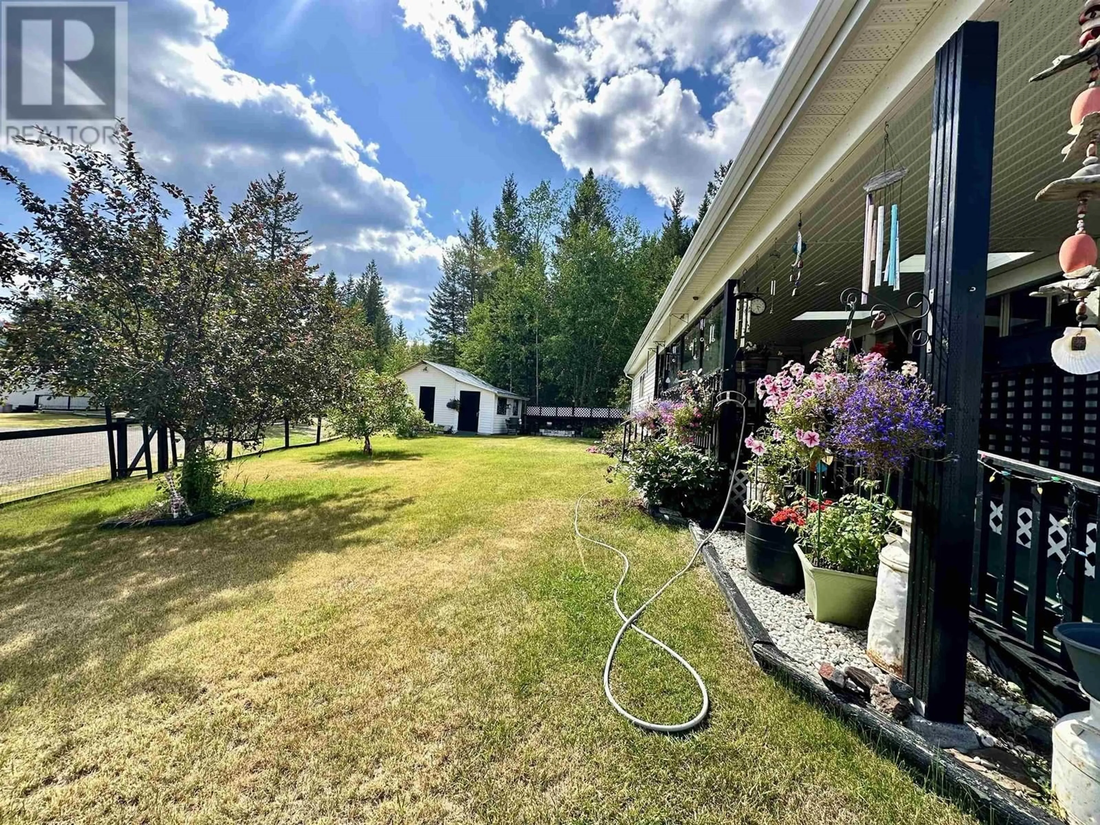 A pic from exterior of the house or condo, the fenced backyard for 21 208 EIGHTH STREET, 100 Mile House British Columbia V0K2E0