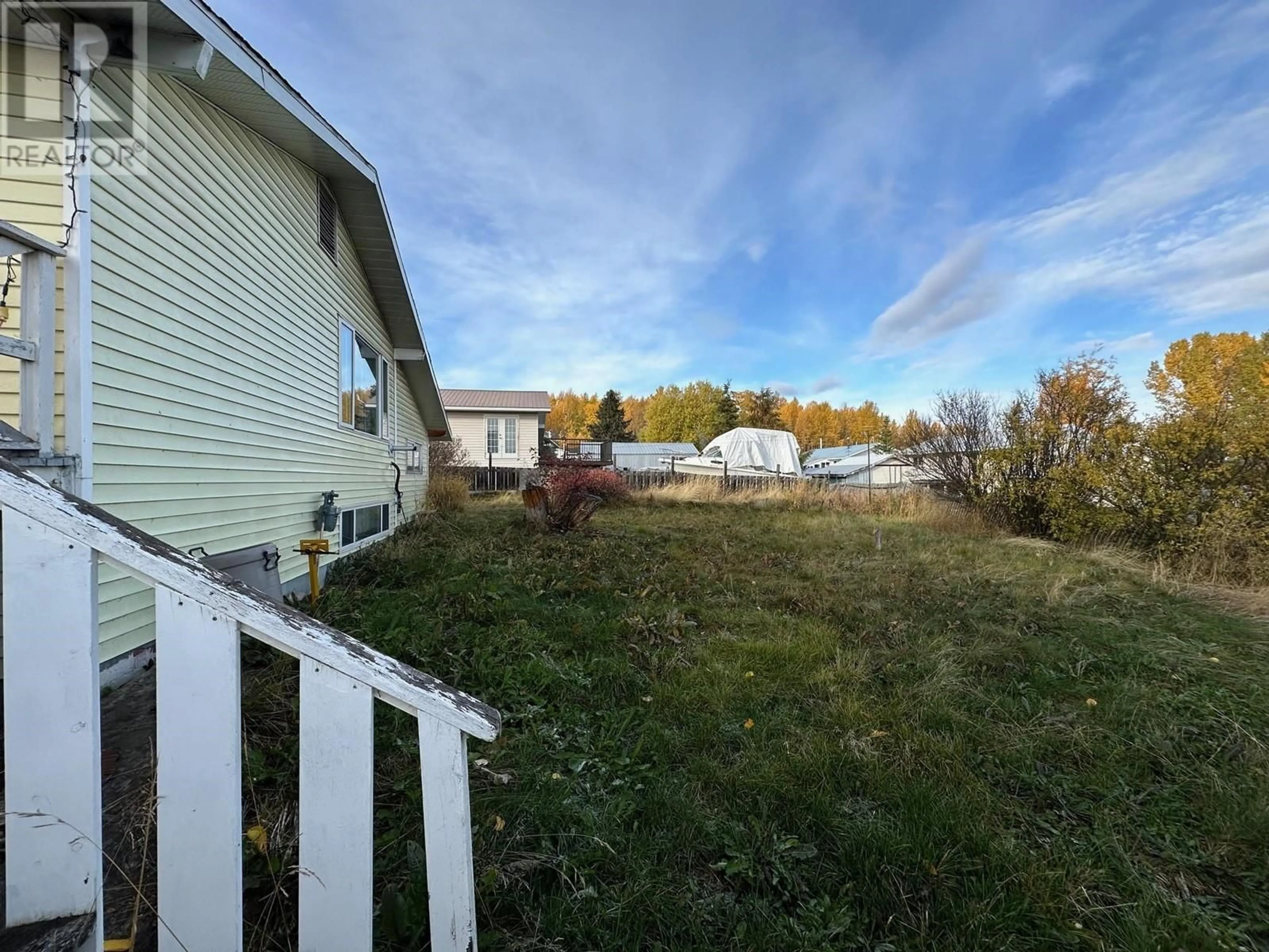 Frontside or backside of a home, the fenced backyard for 6 MCDONALD AVENUE, Granisle British Columbia V0J1W0