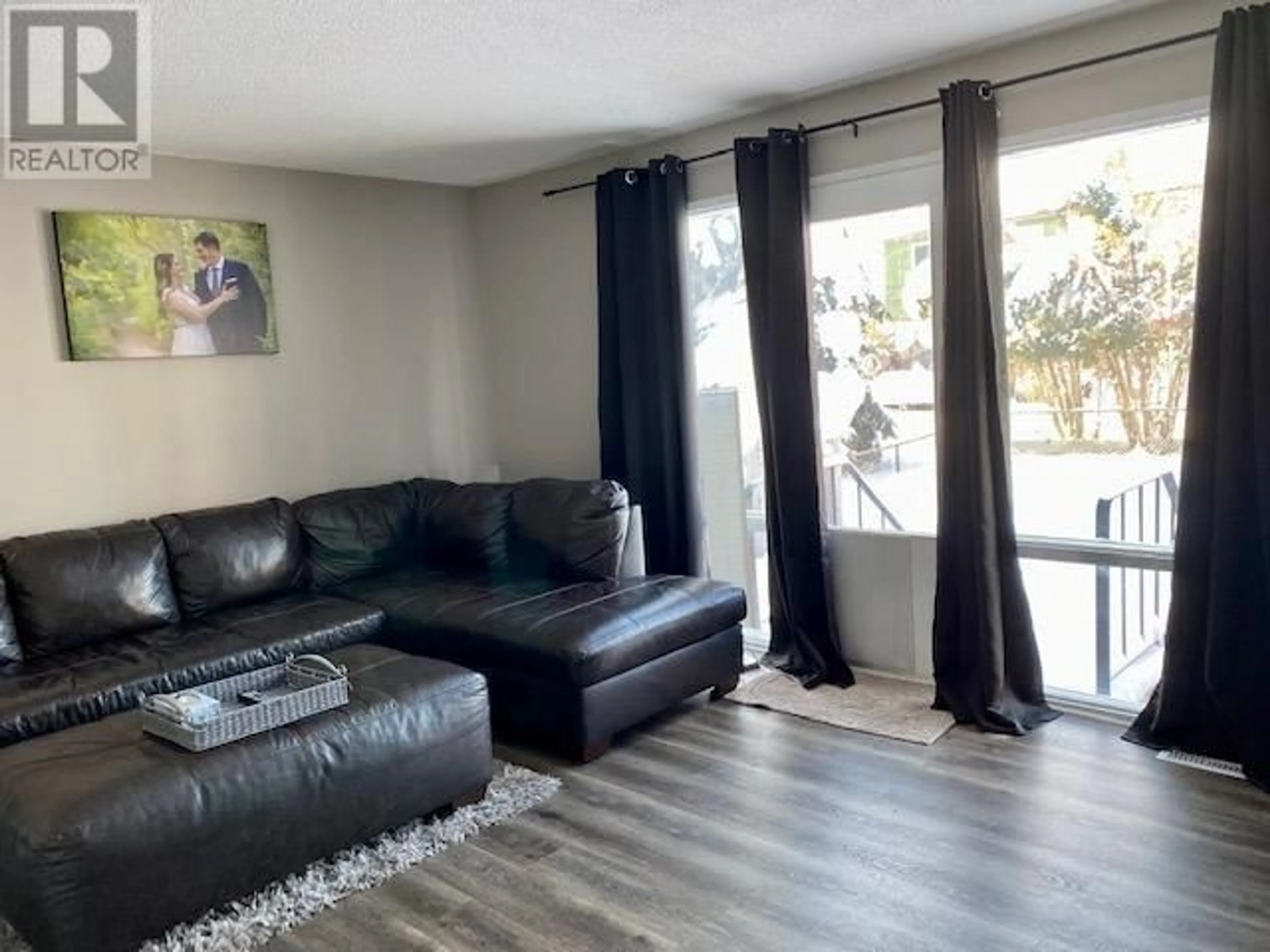 Living room with furniture, wood/laminate floor for 14 - 5320 MOUNTAINVIEW DRIVE, Fort Nelson British Columbia V0C1R0