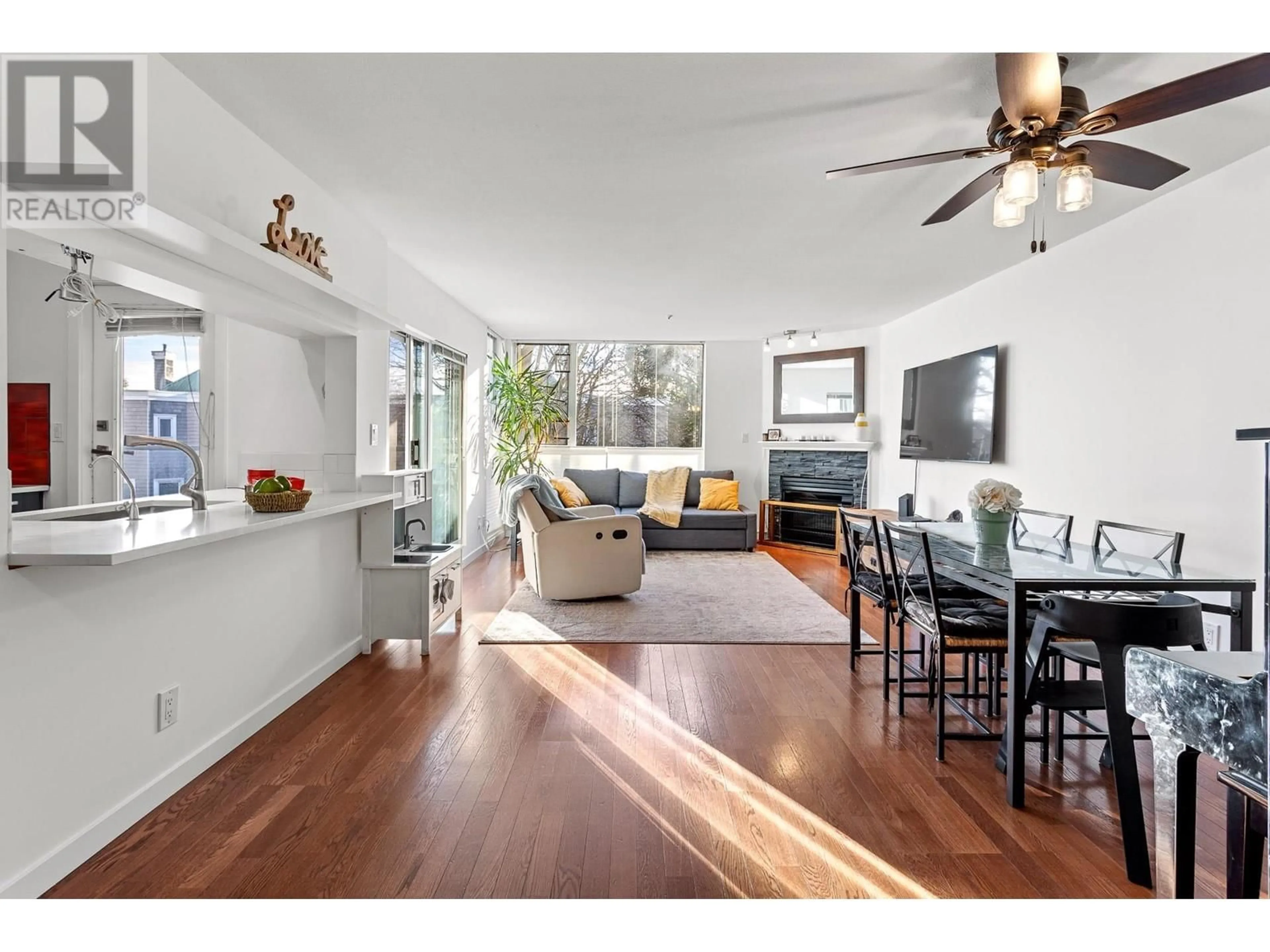 Living room with furniture, wood/laminate floor for 212 - 8460 JELLICOE STREET, Vancouver British Columbia V5S4S8