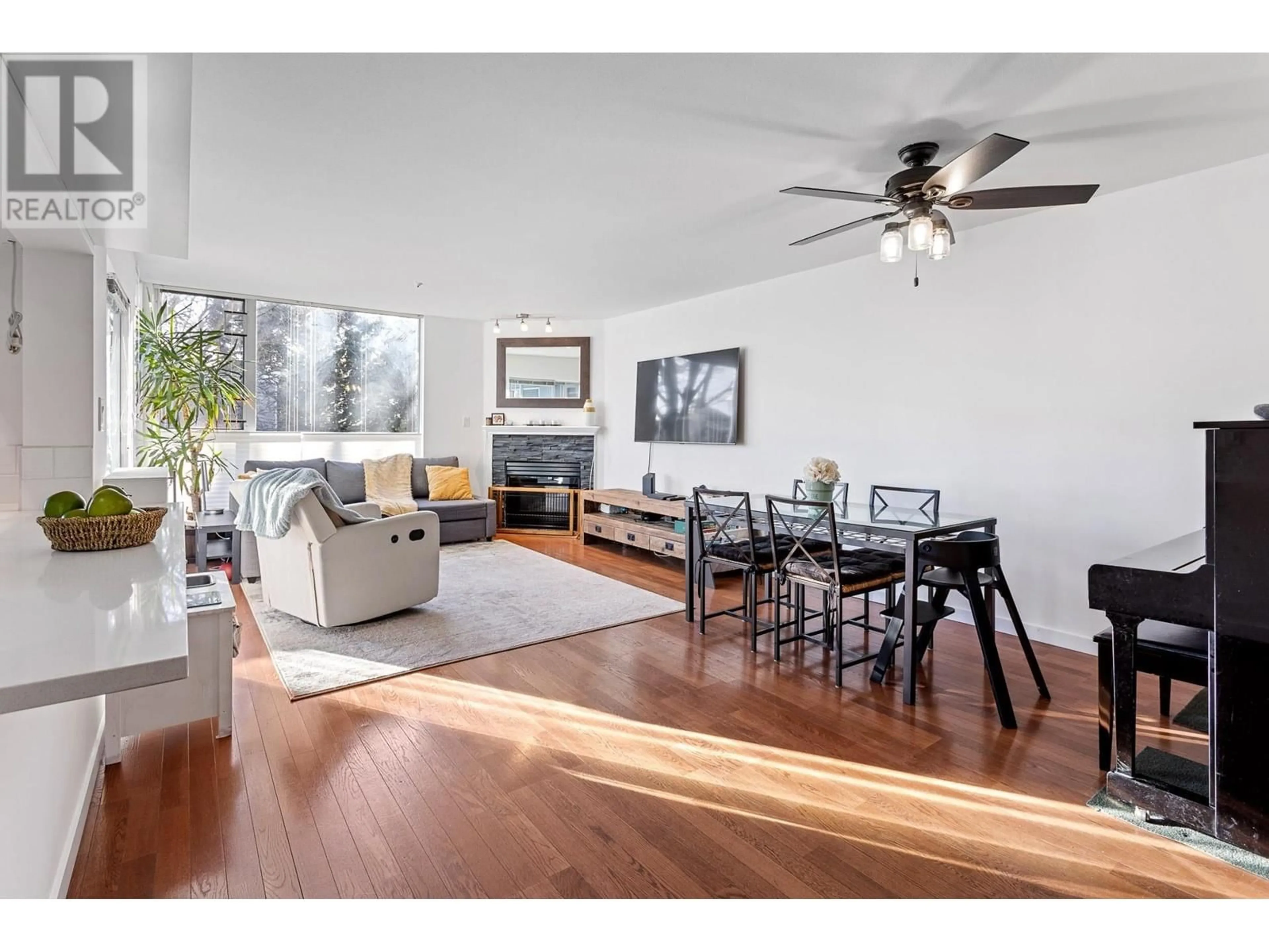 Living room with furniture, wood/laminate floor for 212 - 8460 JELLICOE STREET, Vancouver British Columbia V5S4S8
