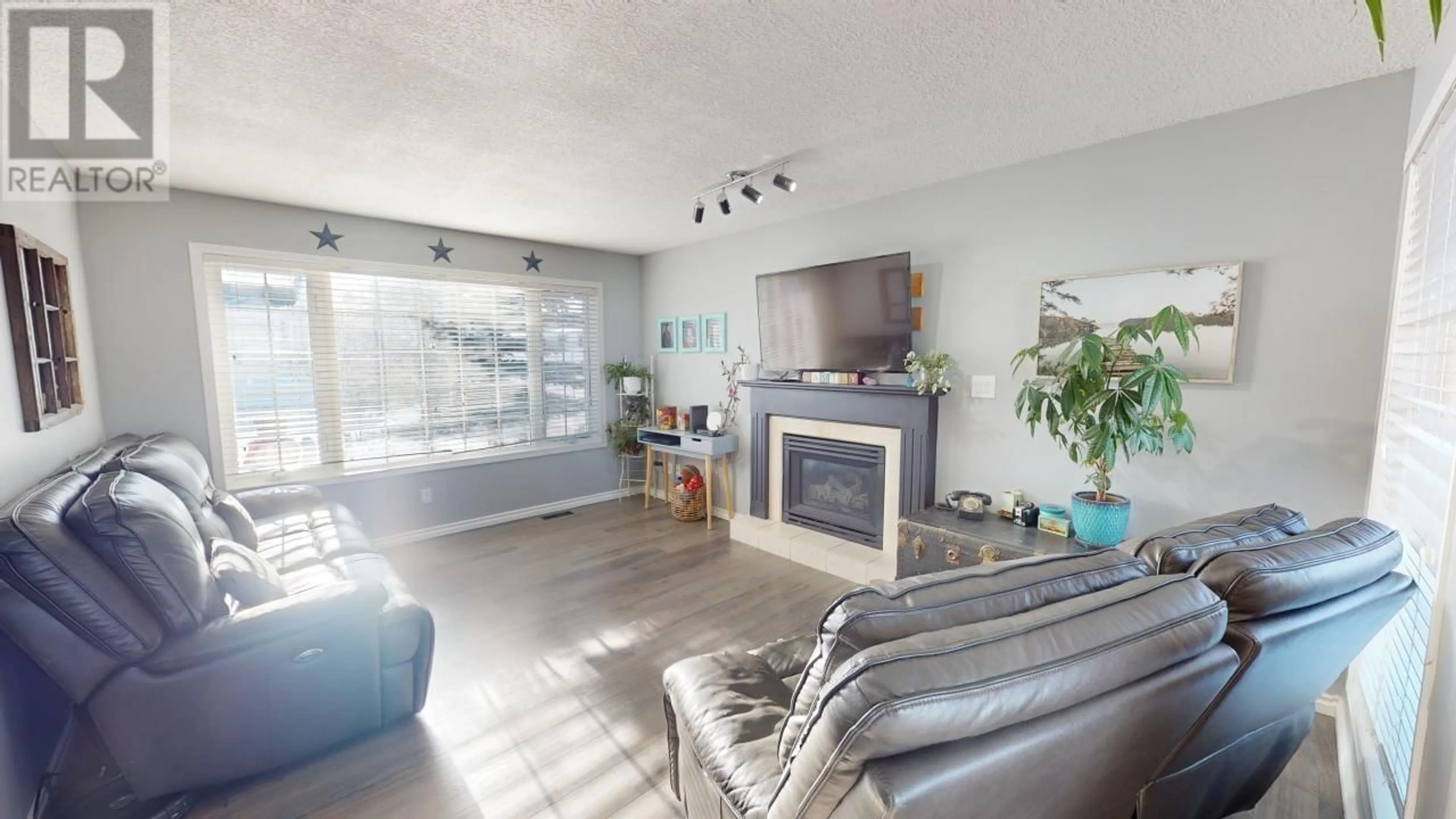 Living room with furniture, wood/laminate floor for 8936 117 AVENUE, Fort St. John British Columbia V1J6P9