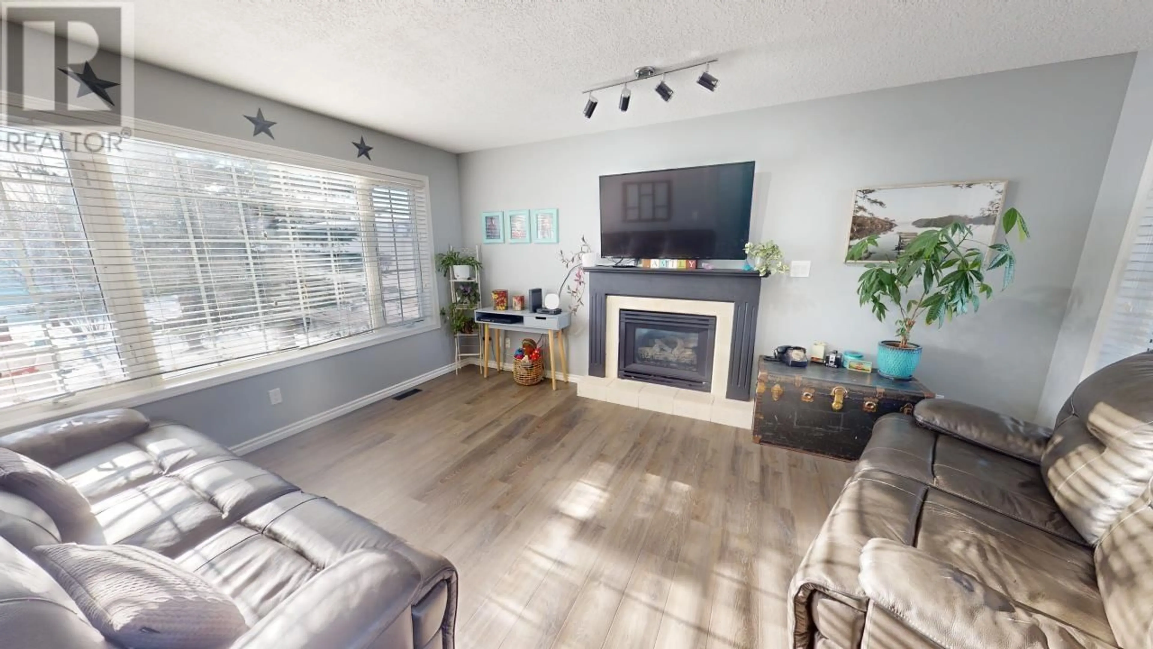 Living room with furniture, wood/laminate floor for 8936 117 AVENUE, Fort St. John British Columbia V1J6P9