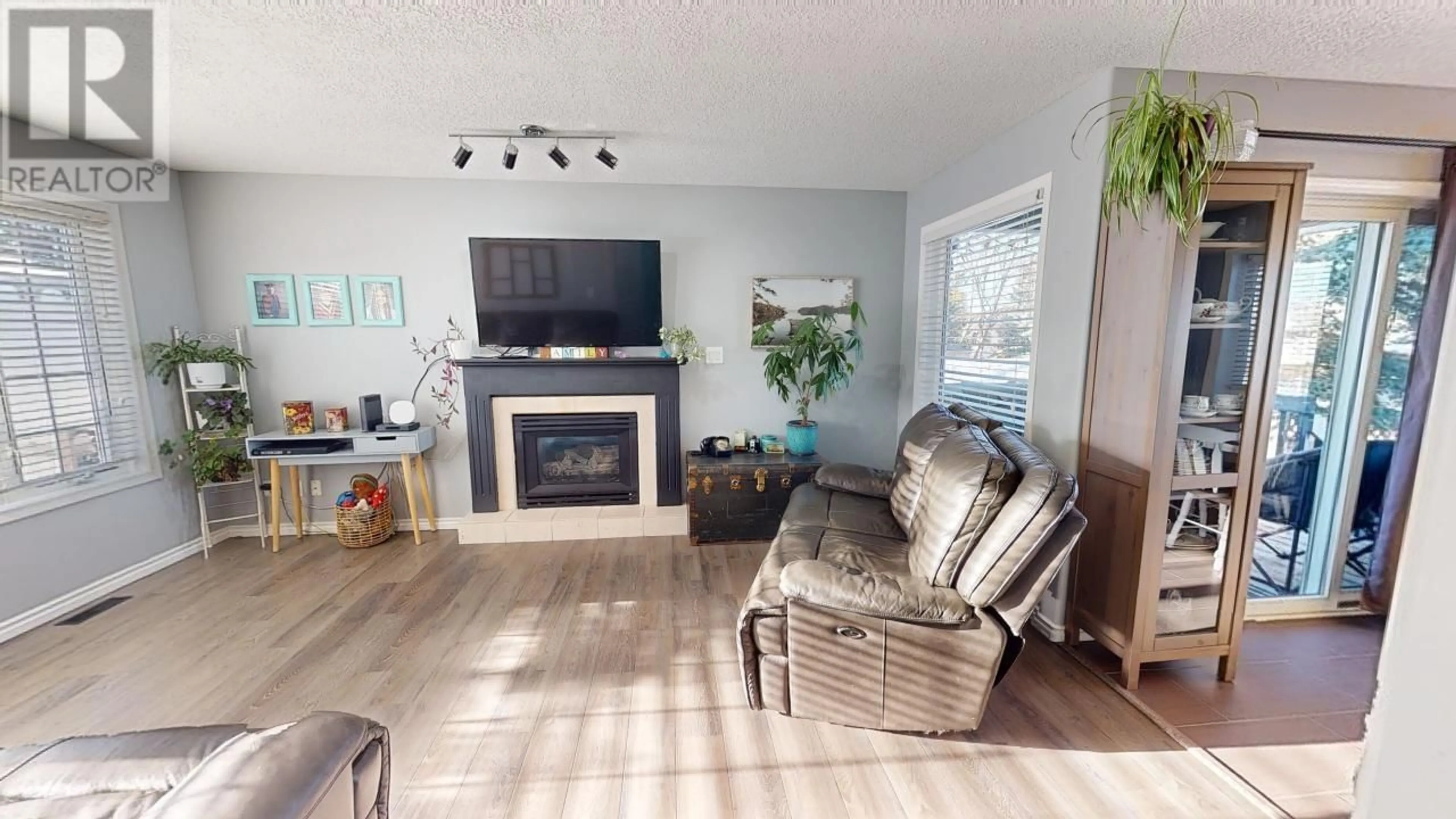 Living room with furniture, wood/laminate floor for 8936 117 AVENUE, Fort St. John British Columbia V1J6P9