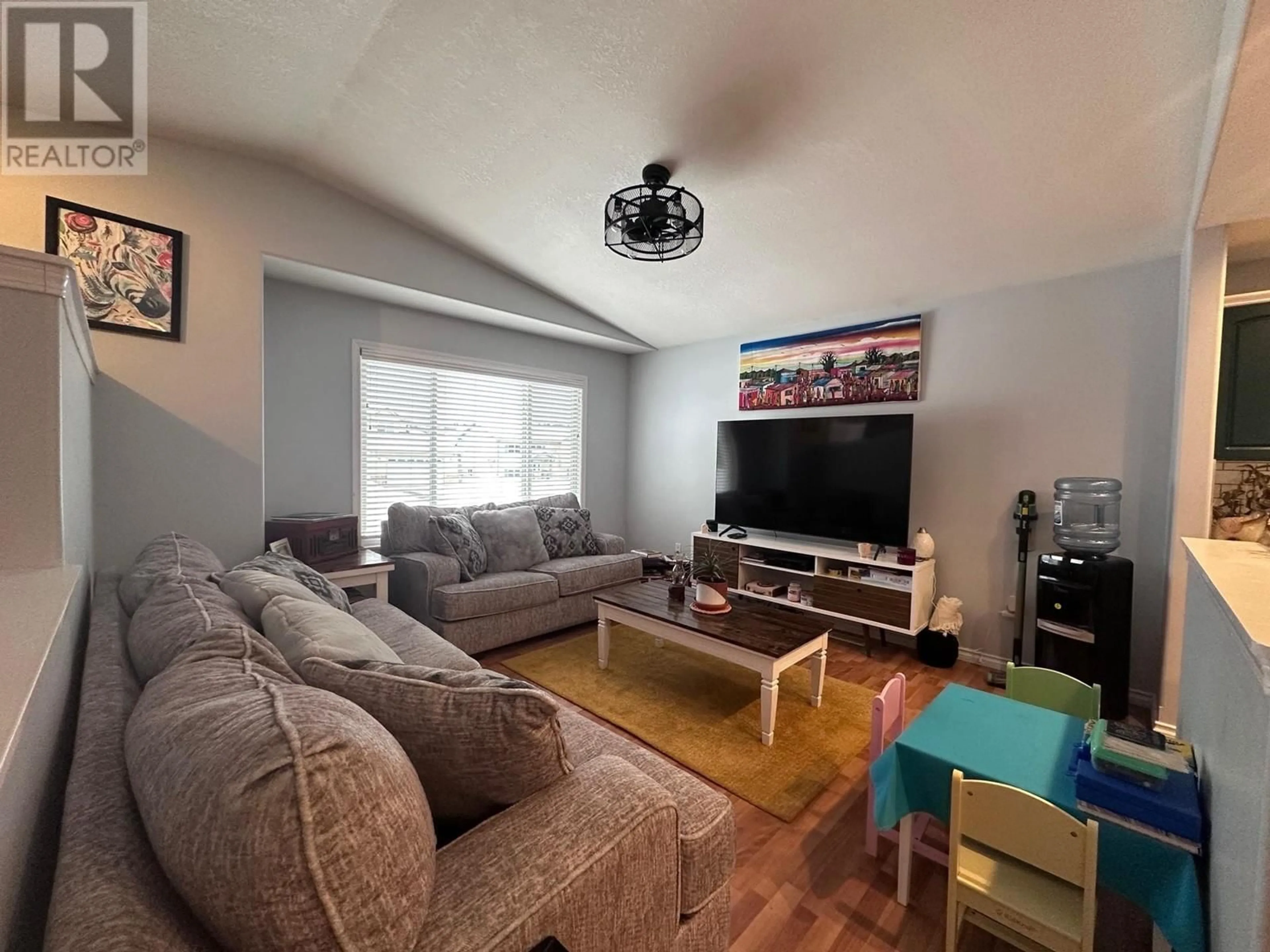 Living room with furniture, wood/laminate floor for 4413 HERITAGE CRESCENT, Fort Nelson British Columbia V0C1R0