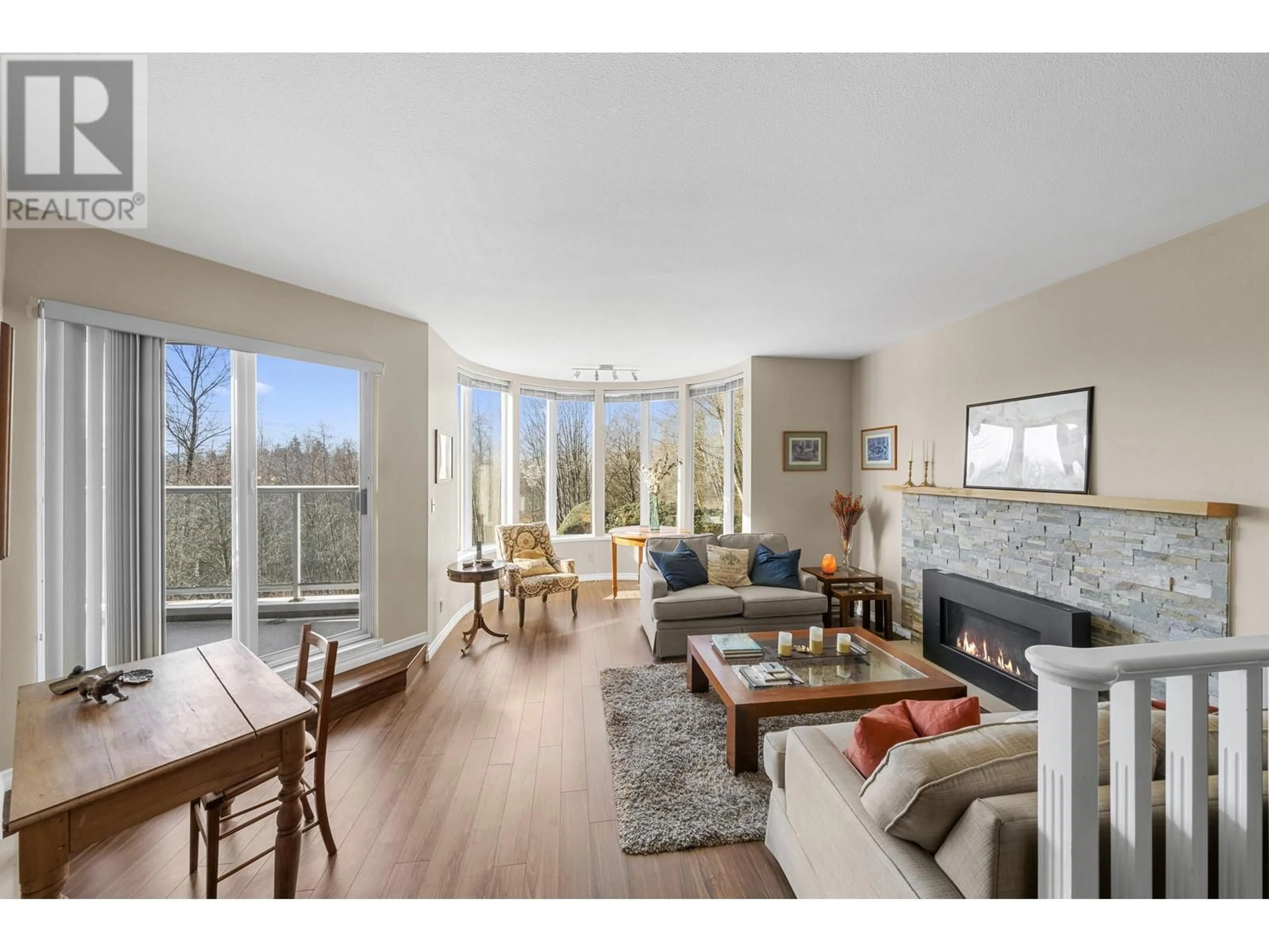 Living room with furniture, wood/laminate floor for 210 999 BERKLEY ROAD, North Vancouver British Columbia V7H1Y3