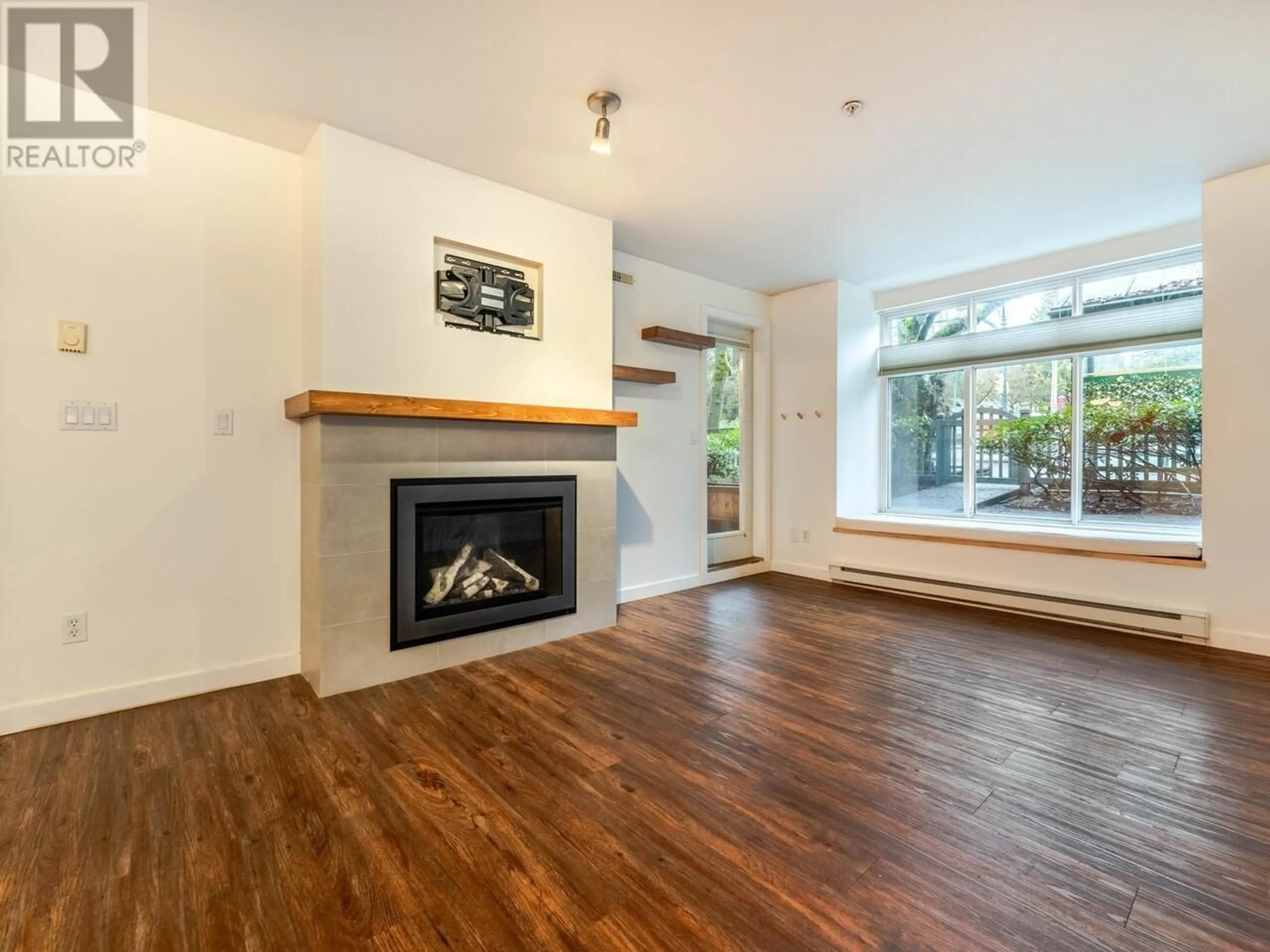 Living room with furniture, wood/laminate floor for 105 1111 LYNN VALLEY ROAD, North Vancouver British Columbia V7J3V4