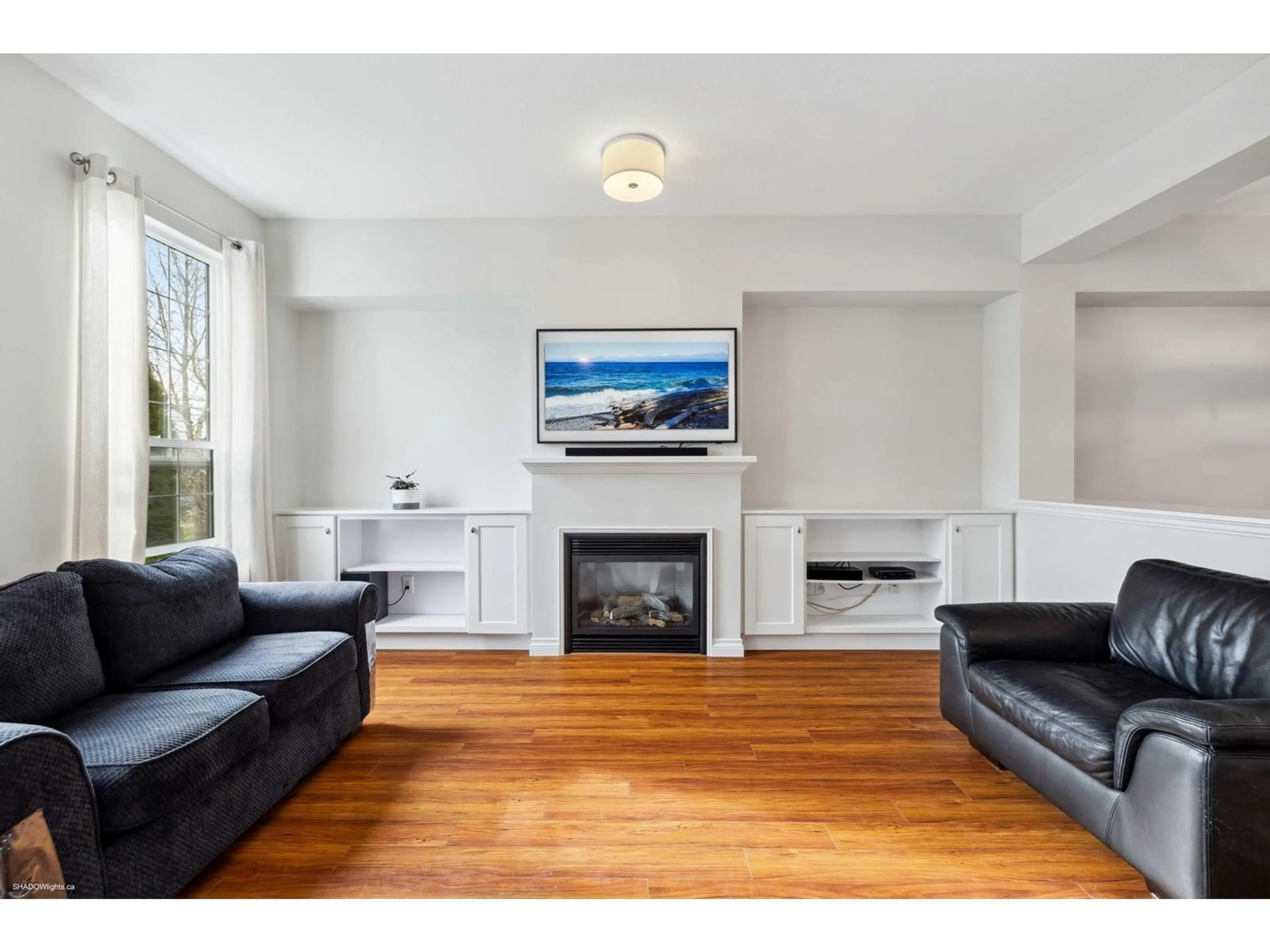 Living room with furniture, wood/laminate floor for 18025 70 AVENUE, Surrey British Columbia V3S6X3