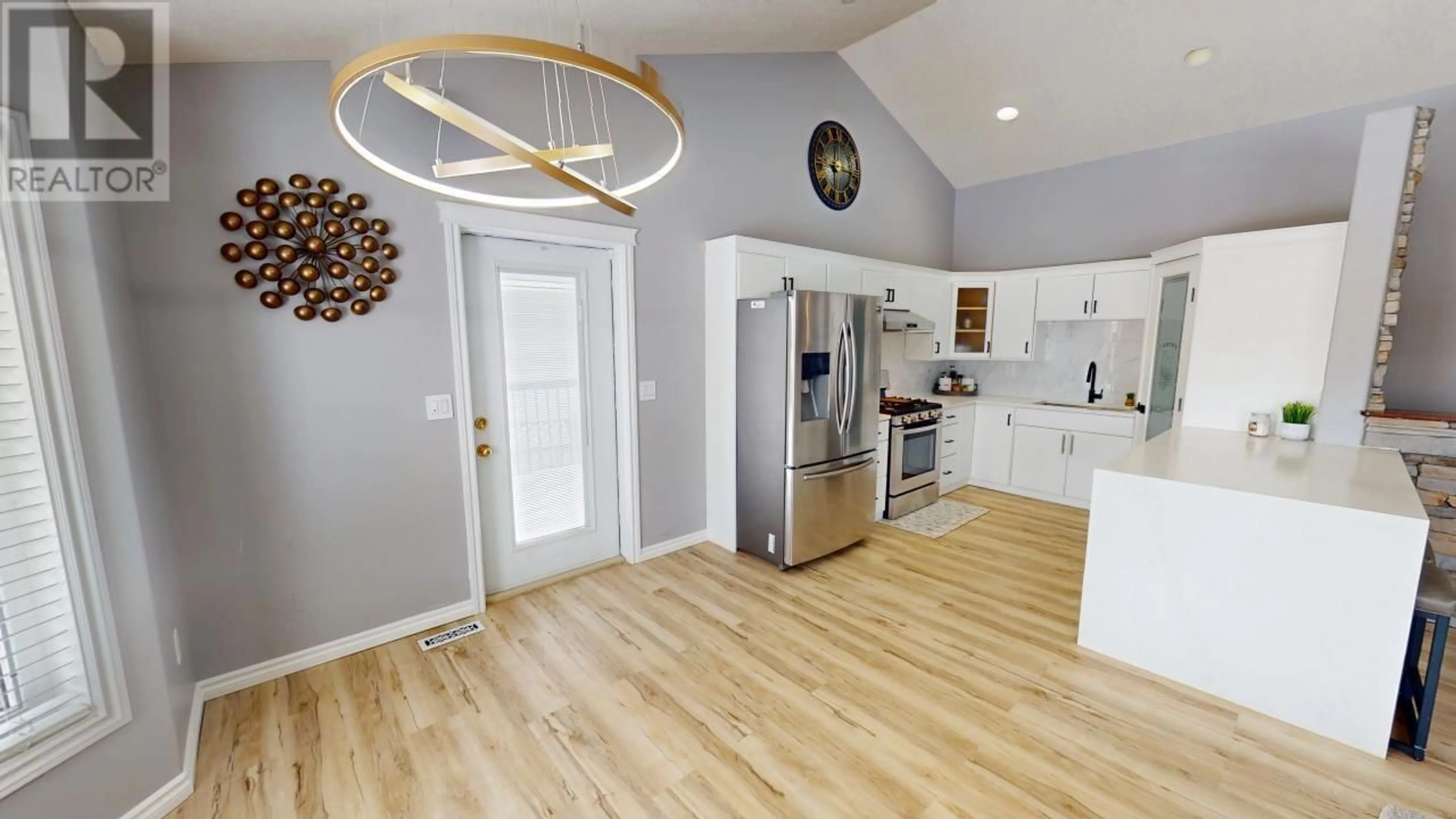 Open concept kitchen, wood/laminate floor for 10328 114 AVENUE, Fort St. John British Columbia V1J0C6
