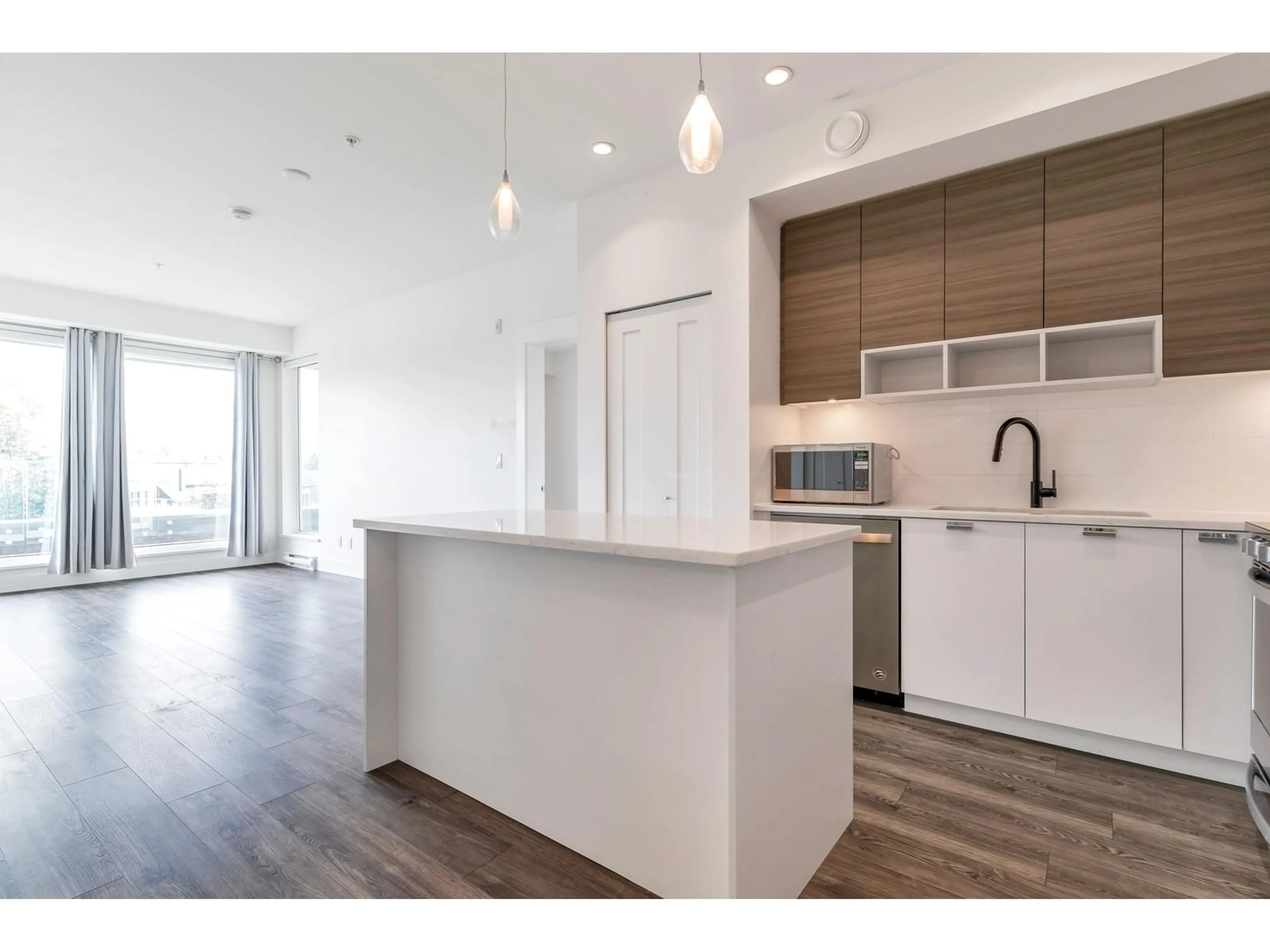 Open concept kitchen, wood/laminate floor for A211 20727 WILLOUGHBY DRIVE, Langley British Columbia V2Y3N1