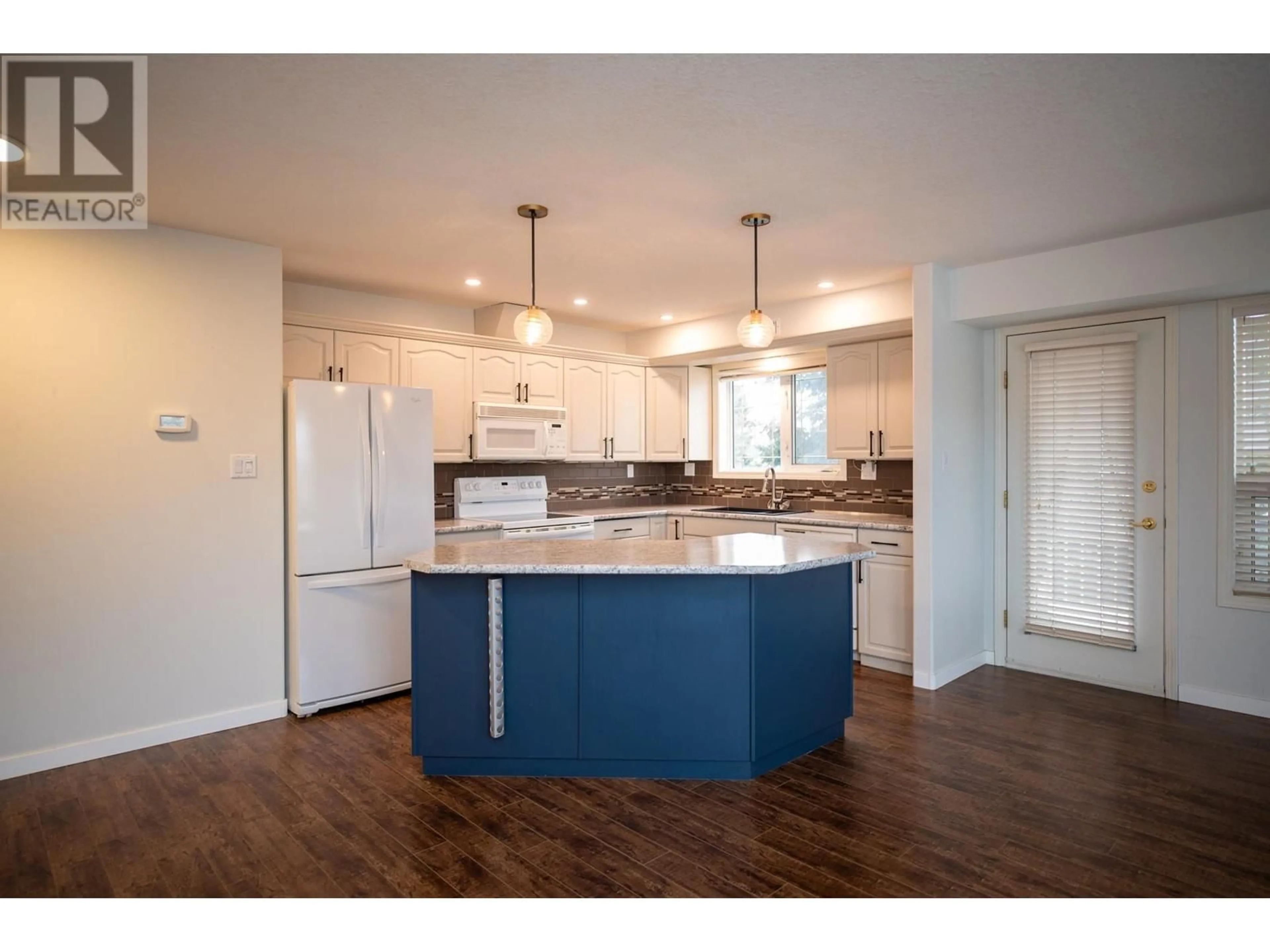 Open concept kitchen, wood/laminate floor for 106 1693 6TH AVENUE, Prince George British Columbia V2L3N5