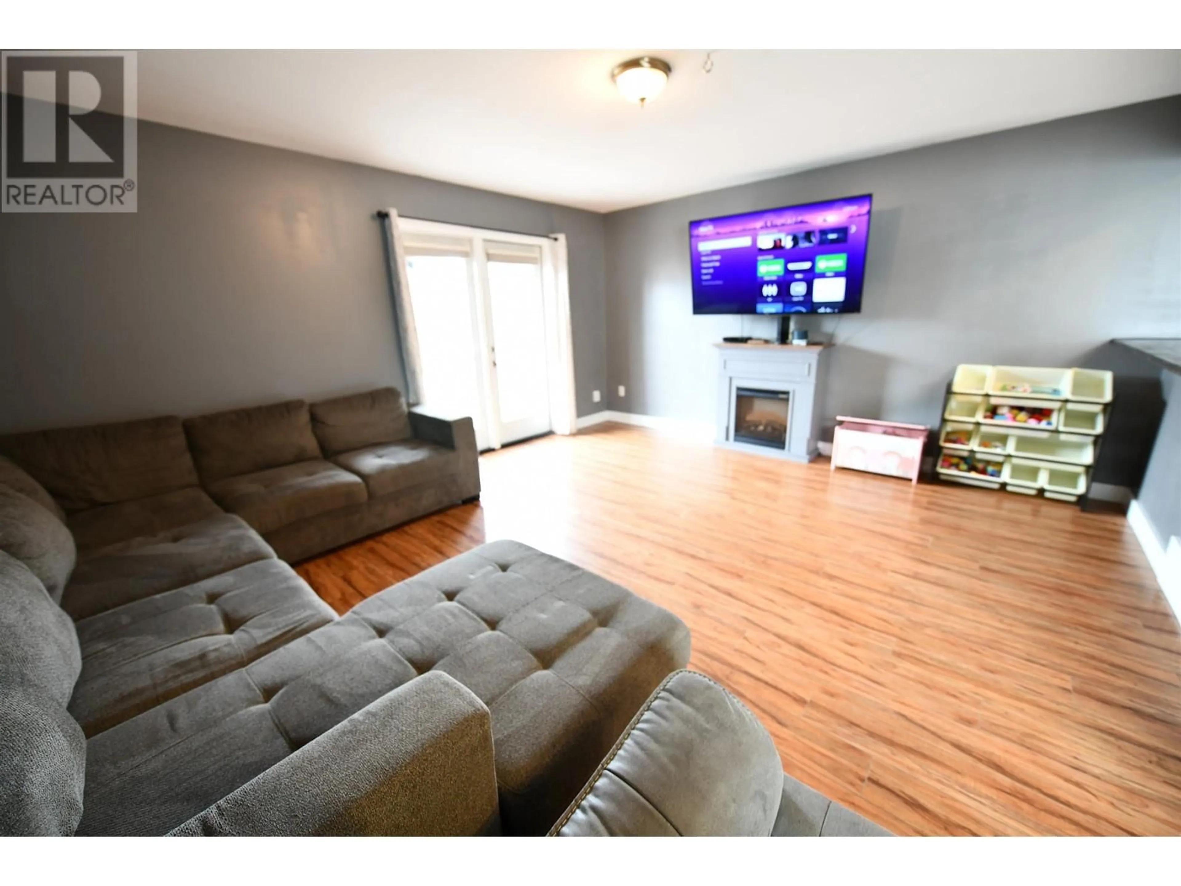 Living room with furniture, wood/laminate floor for 9206 103 AVENUE, Fort St. John British Columbia V1J2G5