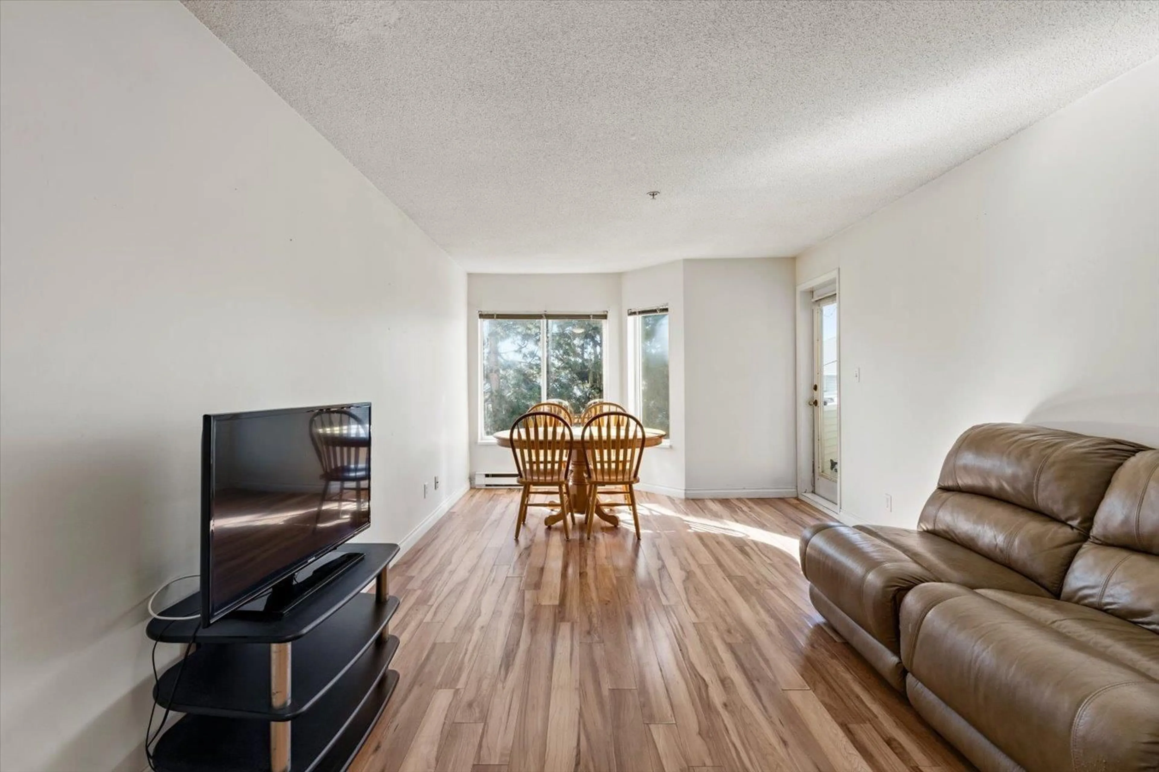 Living room with furniture, wood/laminate floor for 309 12110 80 AVENUE, Surrey British Columbia V3W0V2