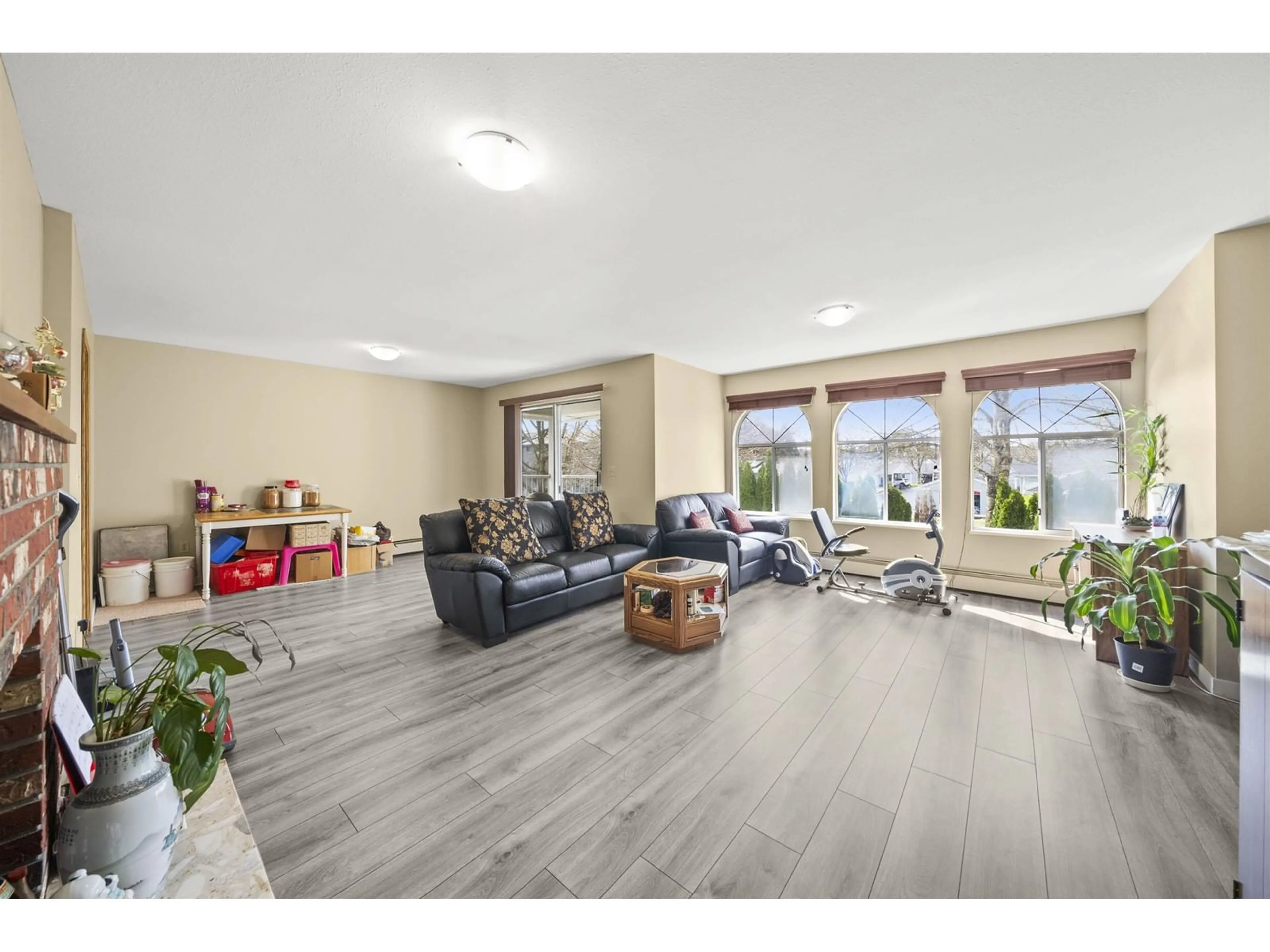 Living room with furniture, wood/laminate floor for 7350 138, Surrey British Columbia V3W5H2