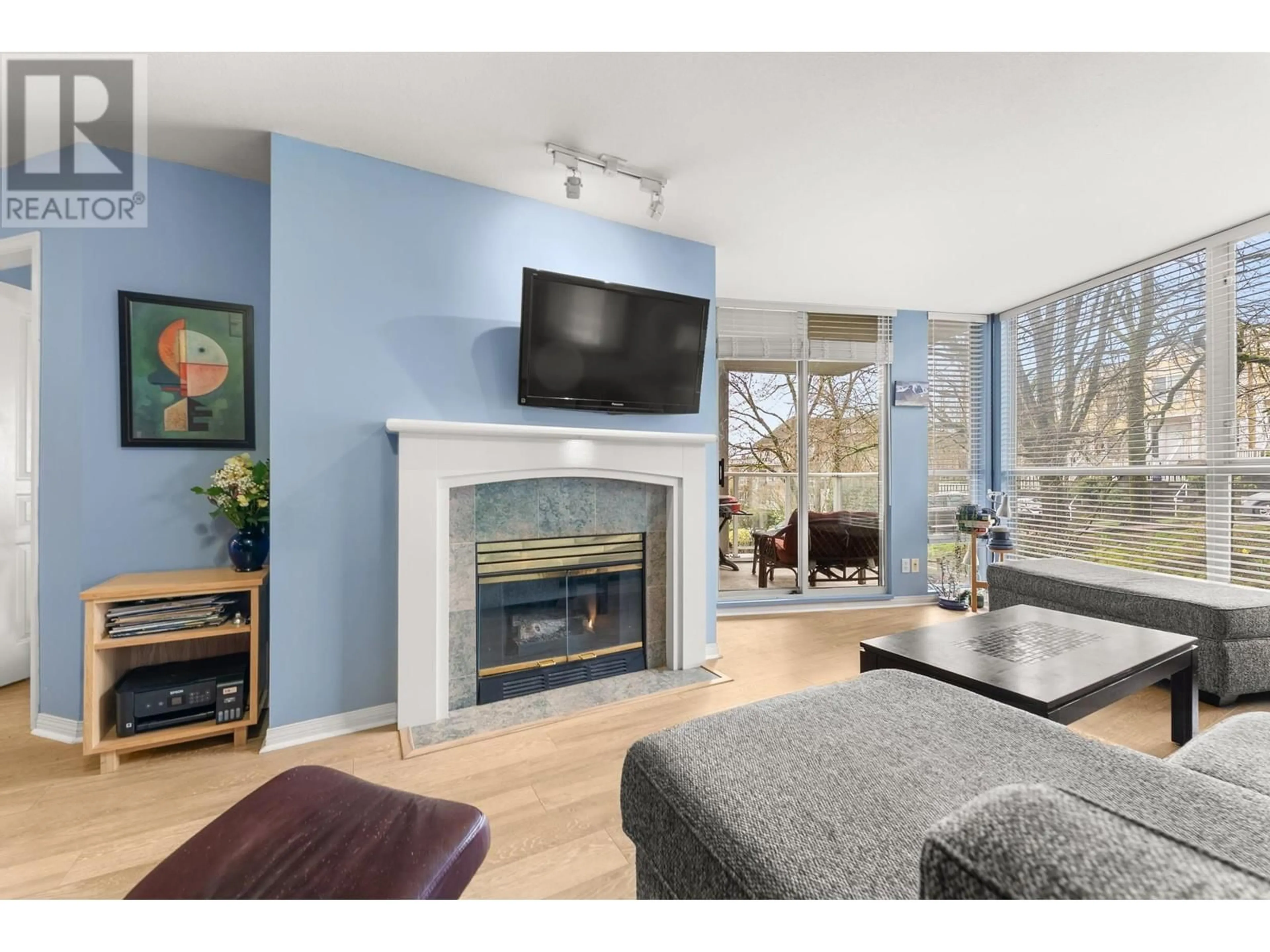 Living room with furniture, wood/laminate floor for 103 - 8420 JELLICOE STREET, Vancouver British Columbia V5S4T1