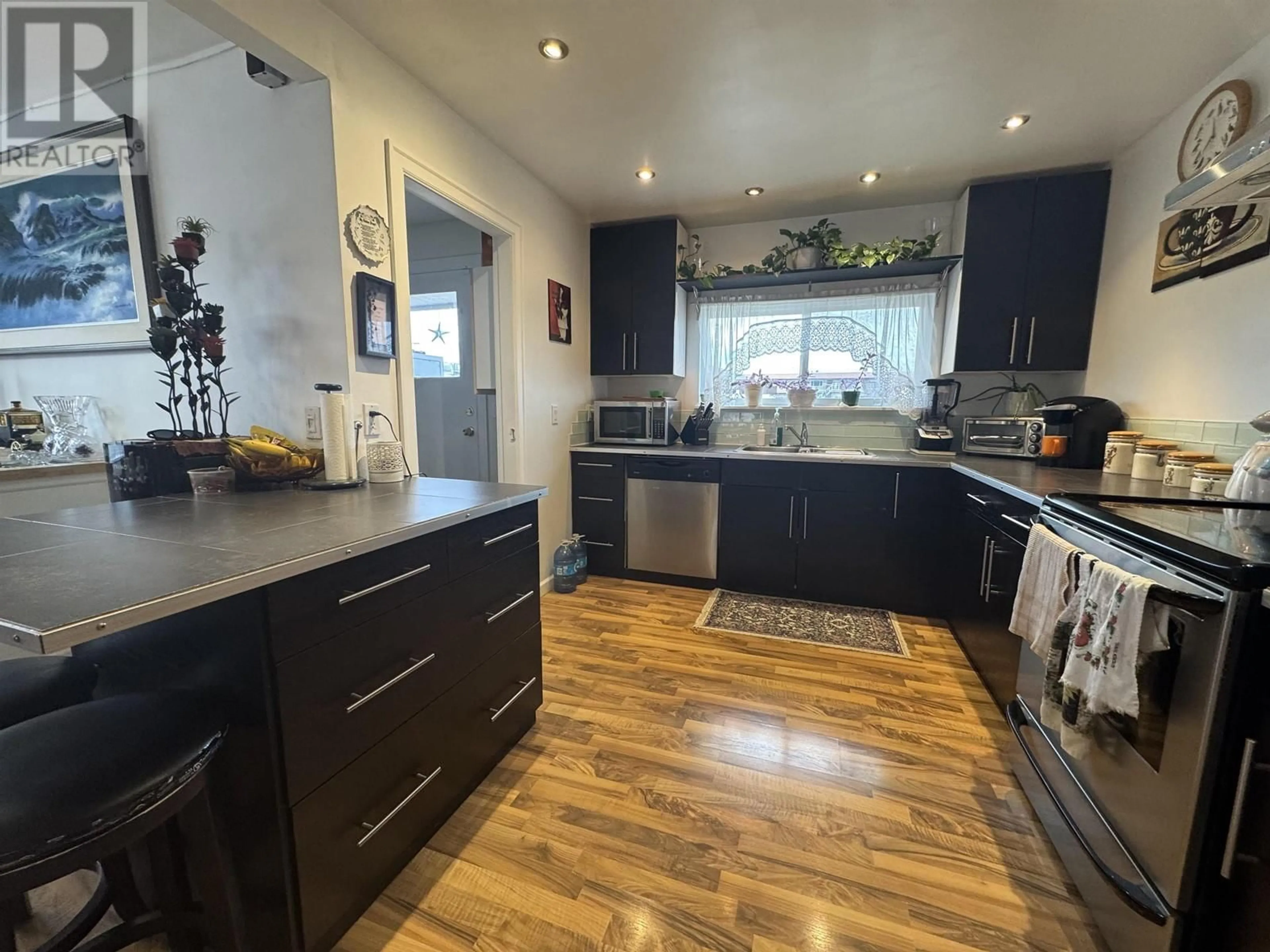 Open concept kitchen, wood/laminate floor for 360 CEDAR AVENUE, 100 Mile House British Columbia V0K2E0